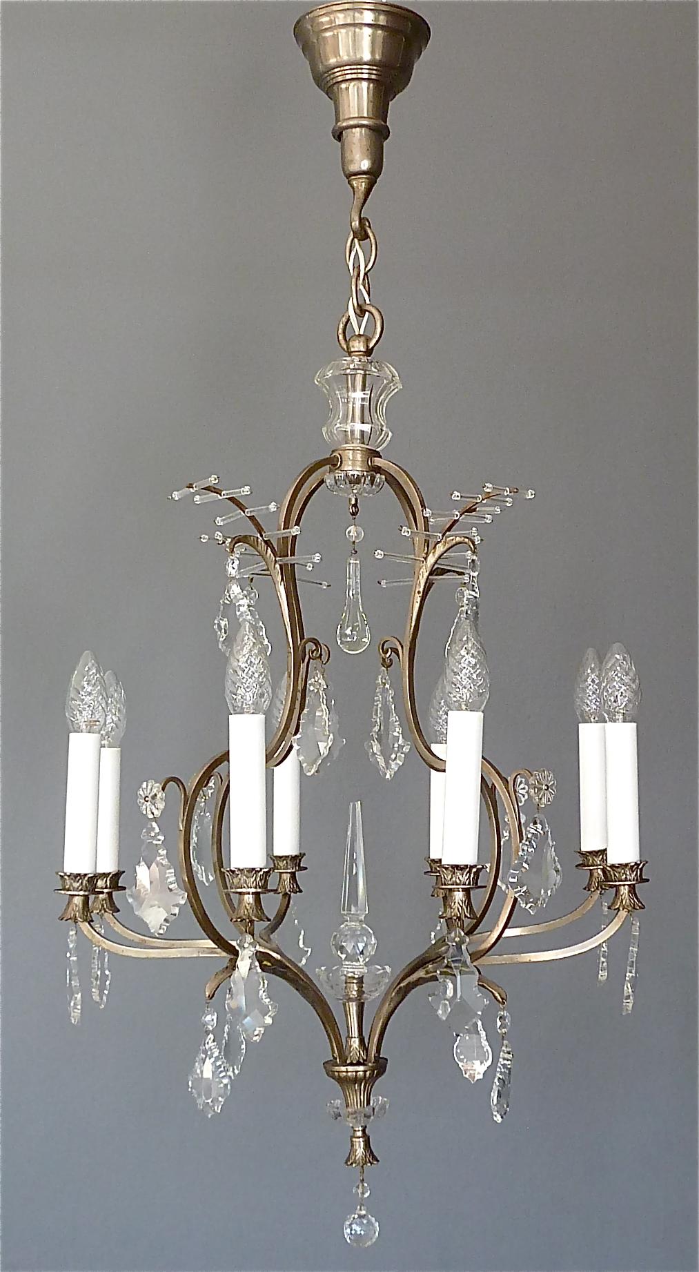 Beautiful classical and antique eight-light chandelier made of patinated metal and hand-cut faceted crystal glass, manufactured in Austria around 1910-1920. This chandelier with lovely details especially the palm-leaf crown motif on top and the
