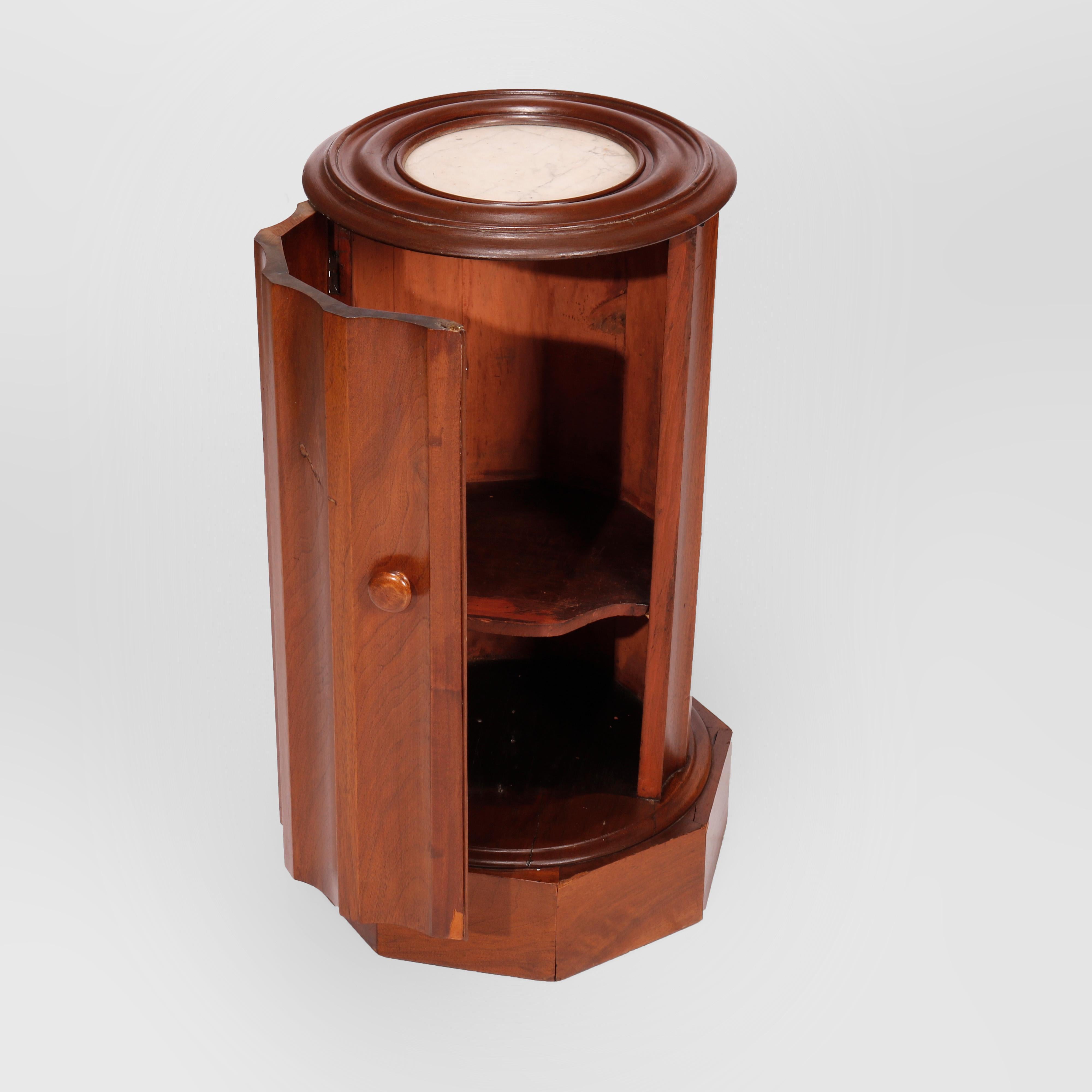 An antique Classical cellarette offers flame mahogany construction in cylindrical form with inset marble top and fluted sides with single door opening to shelved interior and raised on faceted base, c1840

Measures - 28.25''H X 15''W X
