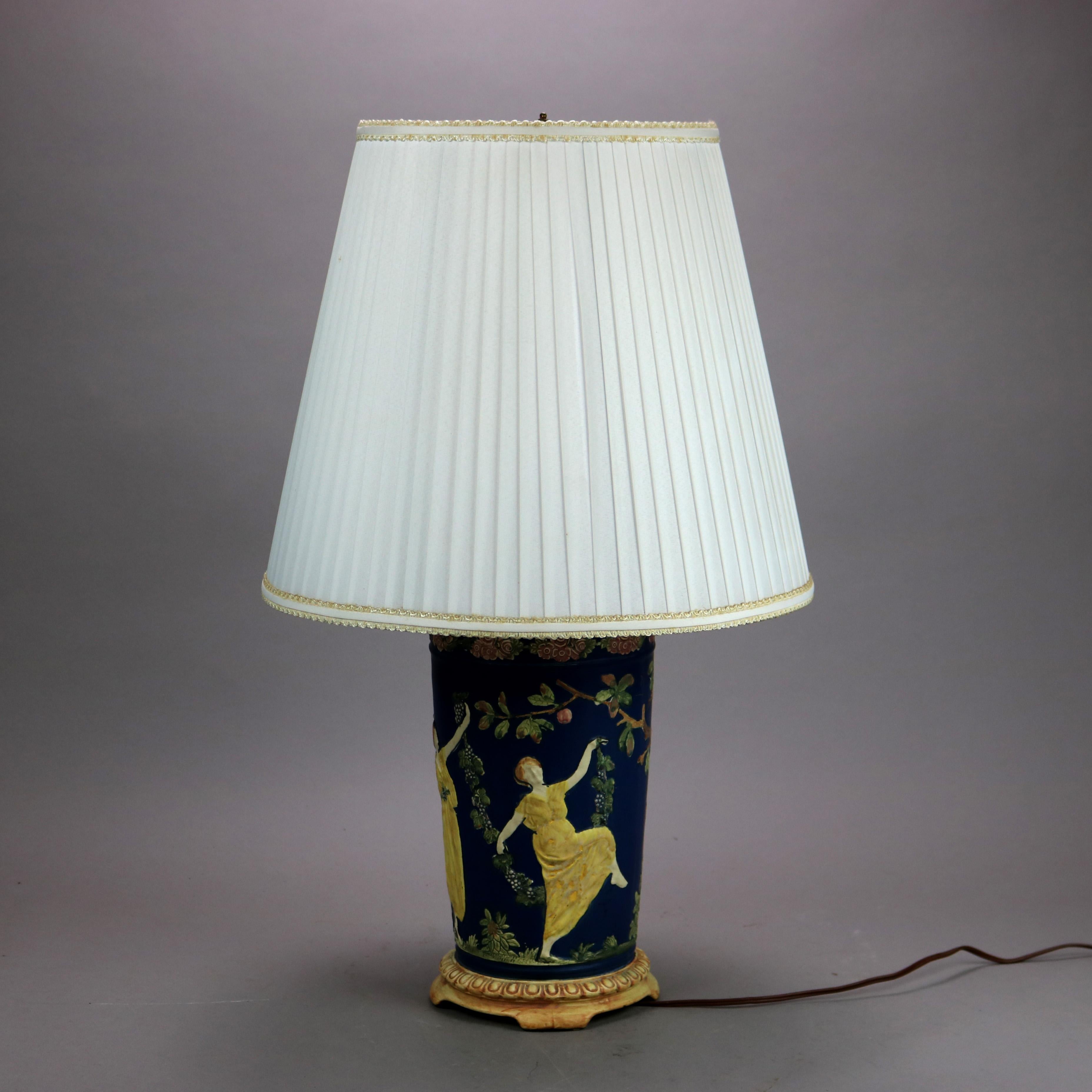 Une base de lampe antique offre un vase en céramique d'art en forme d'urne attribuée à Weller avec des figures grecques dansantes et des éléments de jardin en relief, sur une base à pied, rappelant Wedgwood, c1930

Mesures - 26,5