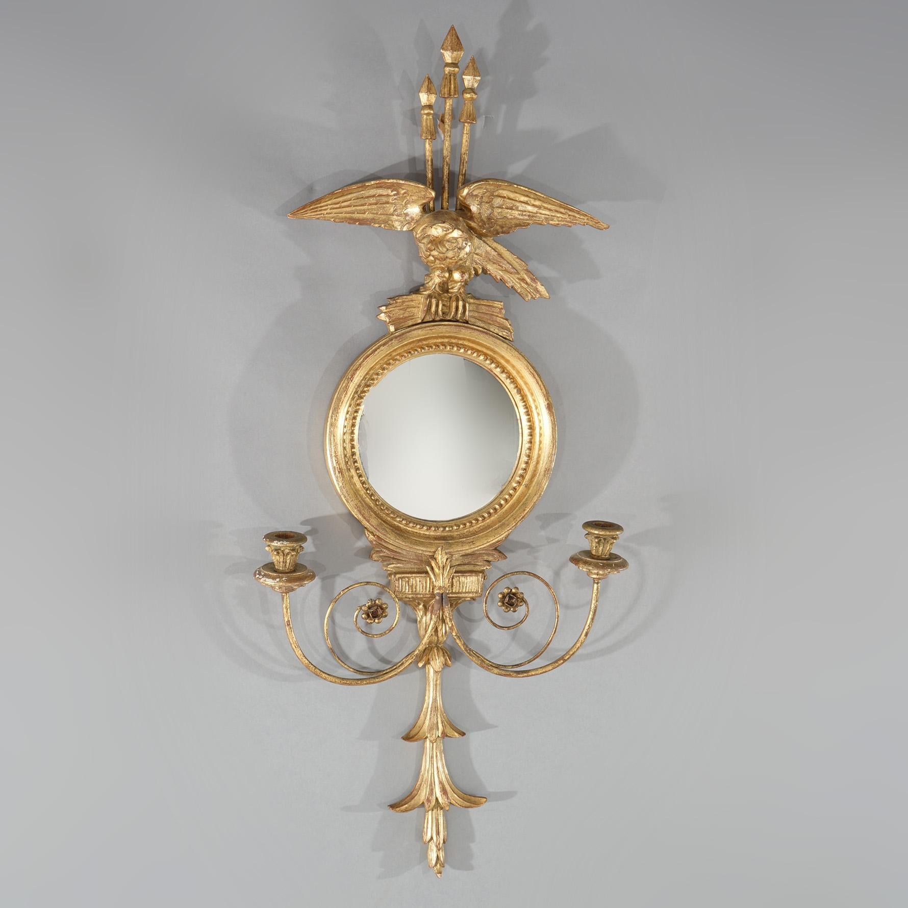An antique Classical Italian figural bullseye mirror offers giltwood construction with eagle or phoenix crest over convex mirror having double scroll form arms terminating in candle sockets, c1920

Measures- 37.5''H x 17''W x 3.5''D; 36.5'' x 27.5''
