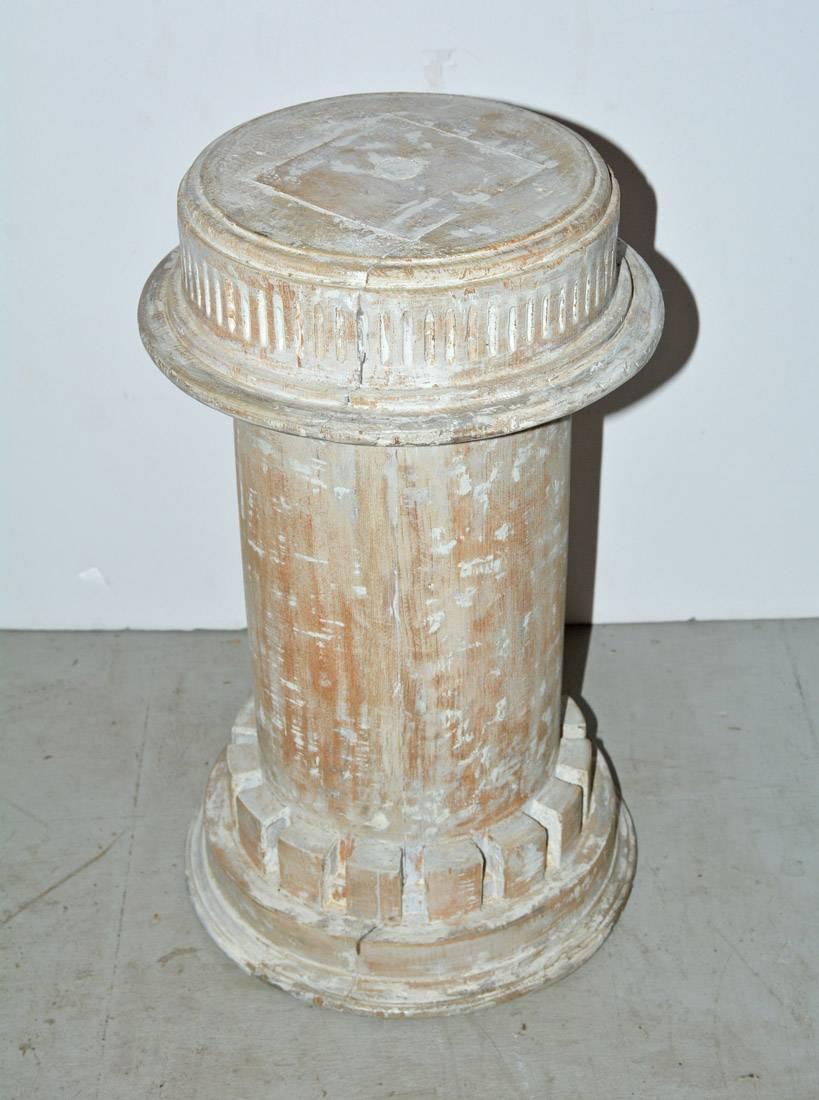 The antique column plinth, pedestal or base in the classical style is encircled at the bottom with dentils and at the top with a fluted design. White paint has been partially removed. Can be used for a small side table base, plant or sculpture