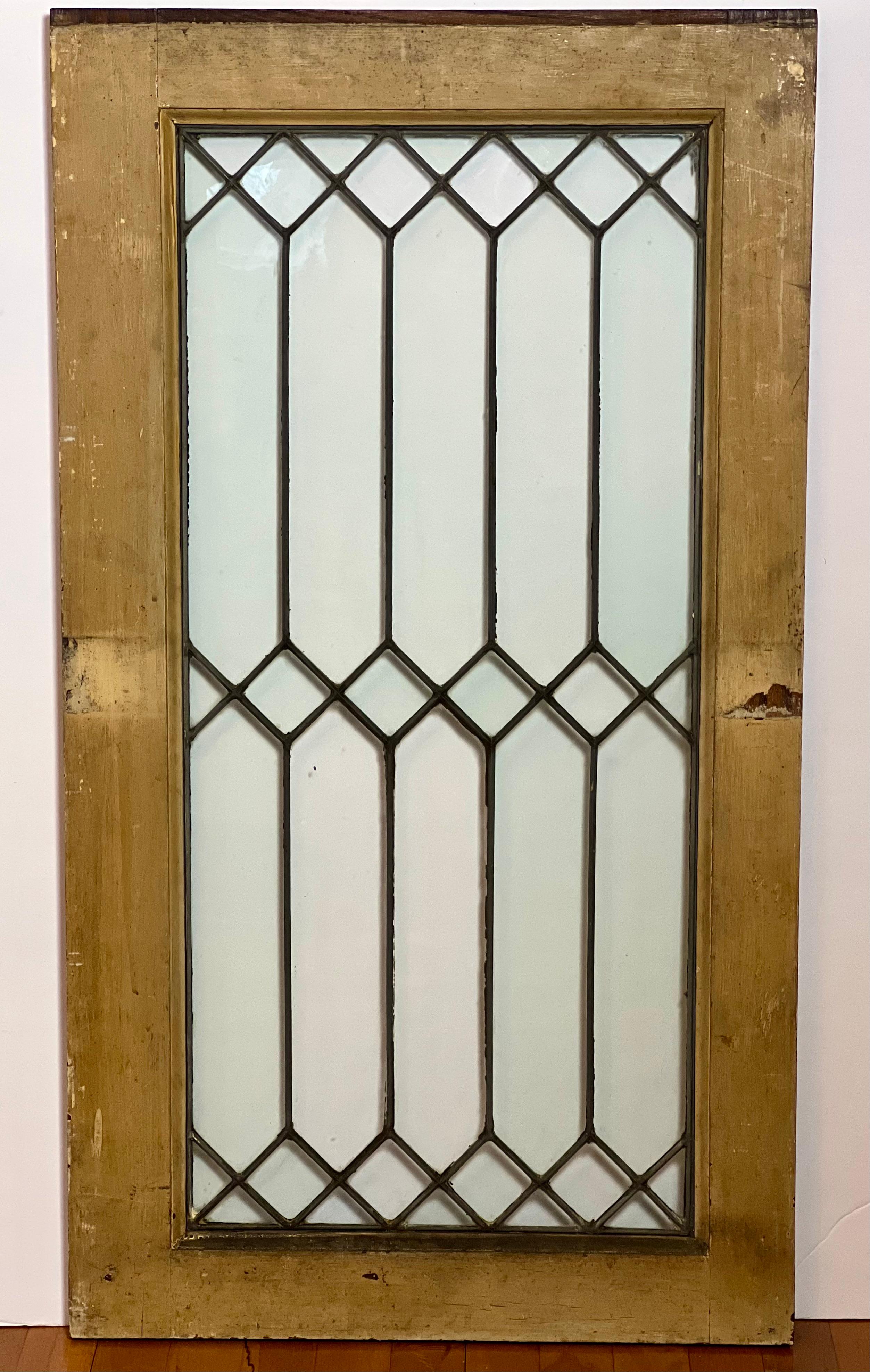 Antique clear leaded glass window in wood frame, c. 1900s.

Wonderful window encased in original wood frame with a clean and crisp, timeless geometrical pattern with straight lines and diamonds. It fully transmits light with clear glass in good