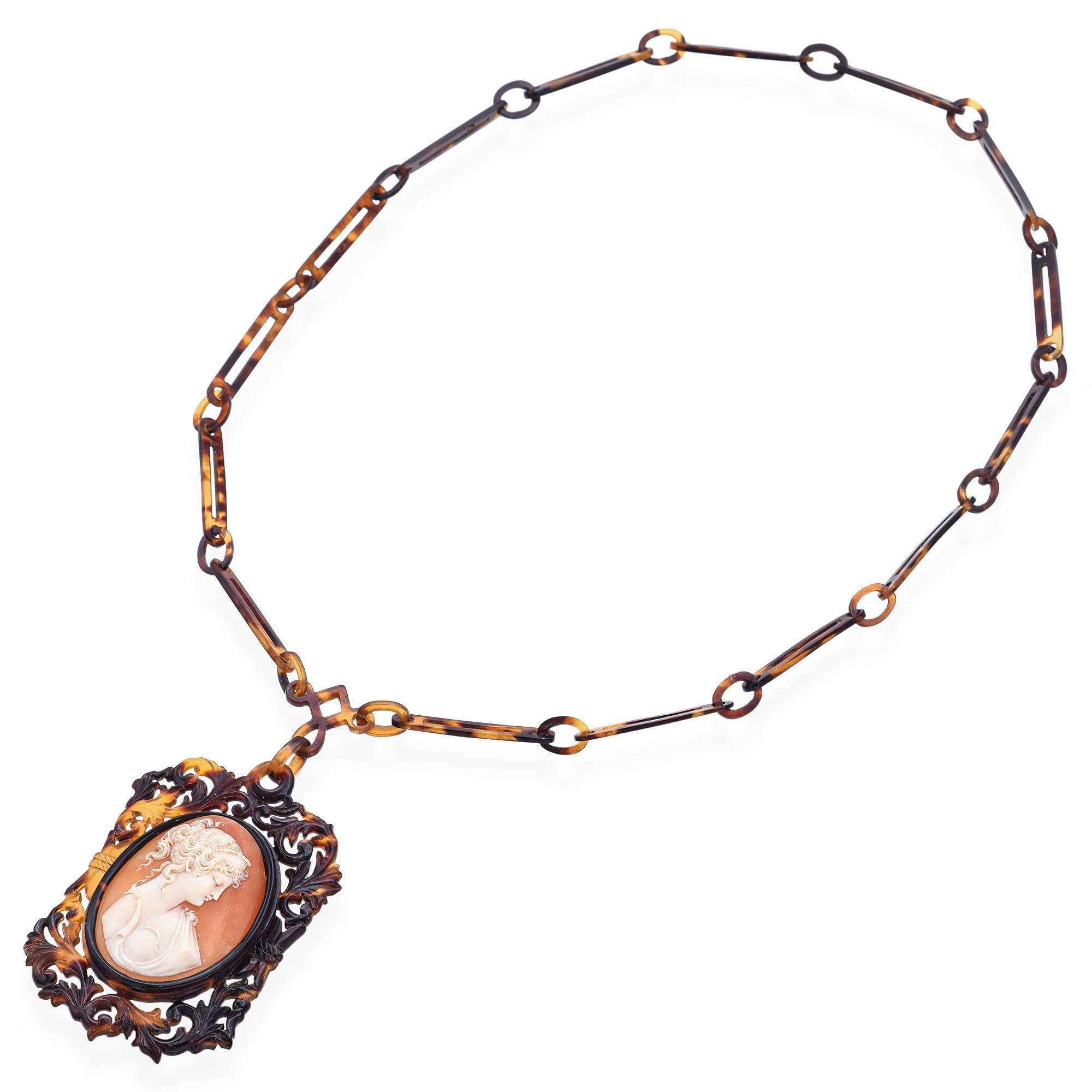 Dominante y enigmático, este broche antiguo presenta un retrato camafeo magistralmente tallado de Cleopatra, la legendaria reina de Egipto, engastado en un rico caparazón de tortuga con motivos naturales. Su perfil regio se capta con delicadeza