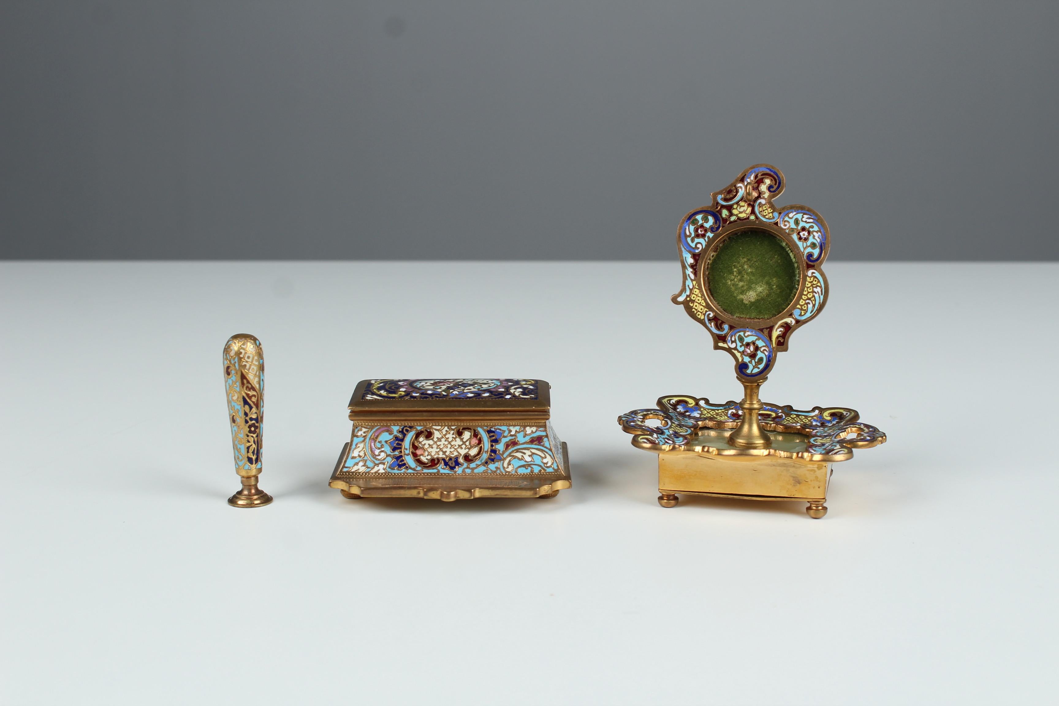 Exceptional Enameled Desk Set of a box, seal stamp and a pocket watch stand, France circa 1880.
Beautiful Cloisonné- enamel work in bold blue, turquoise, red and beige colours.

Measures:
Stamp- or matches-box: 9 x 7 x 4 cm 
Seal Stamp with the