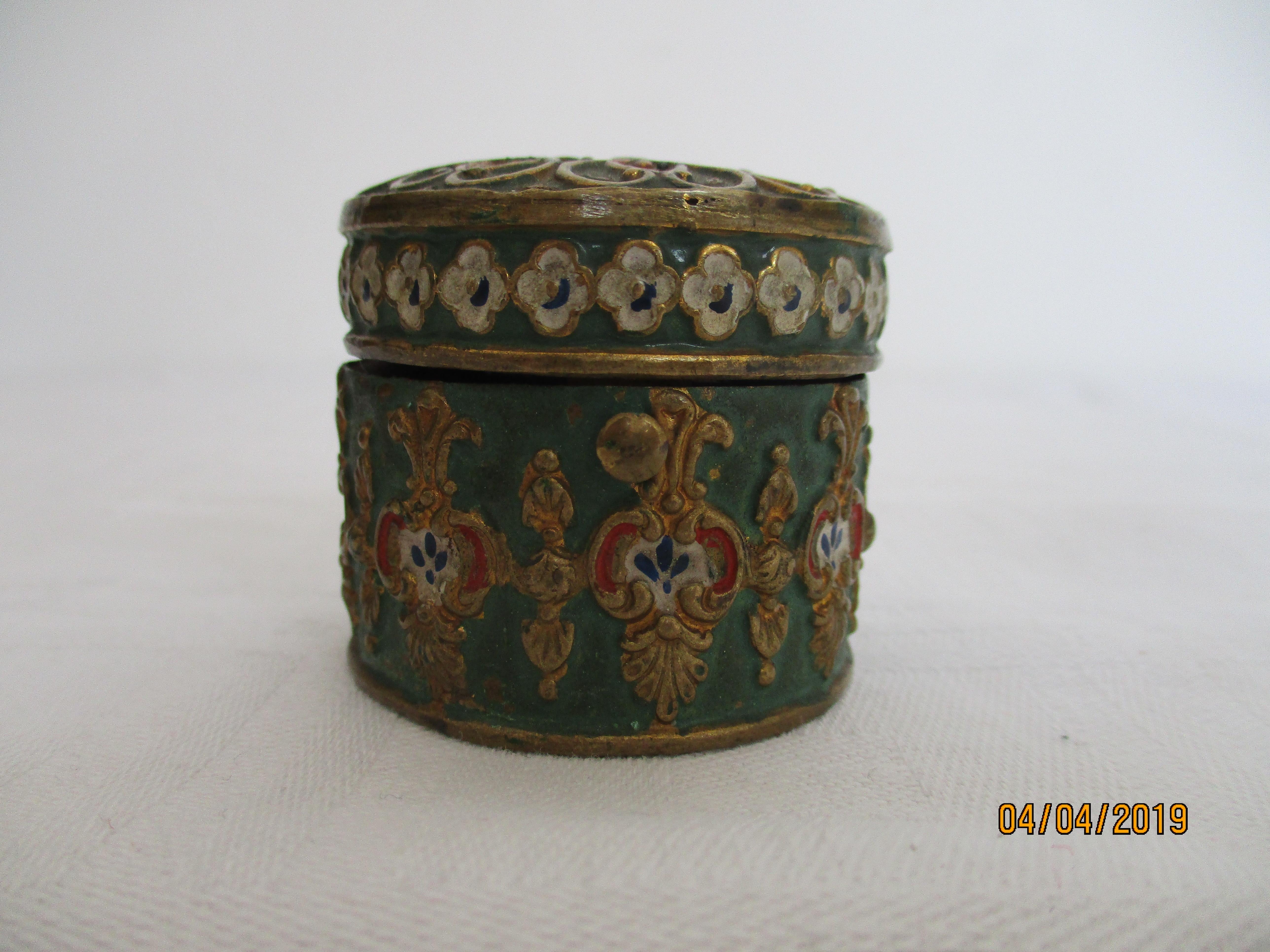 This inkwell comprises a base and hinged cover. The base is elaborately decorated with red, gold, blue and white against a green background. 
The inside of the inkwell is colored red. 
The condition is good with only minor losses to the cloisonne.