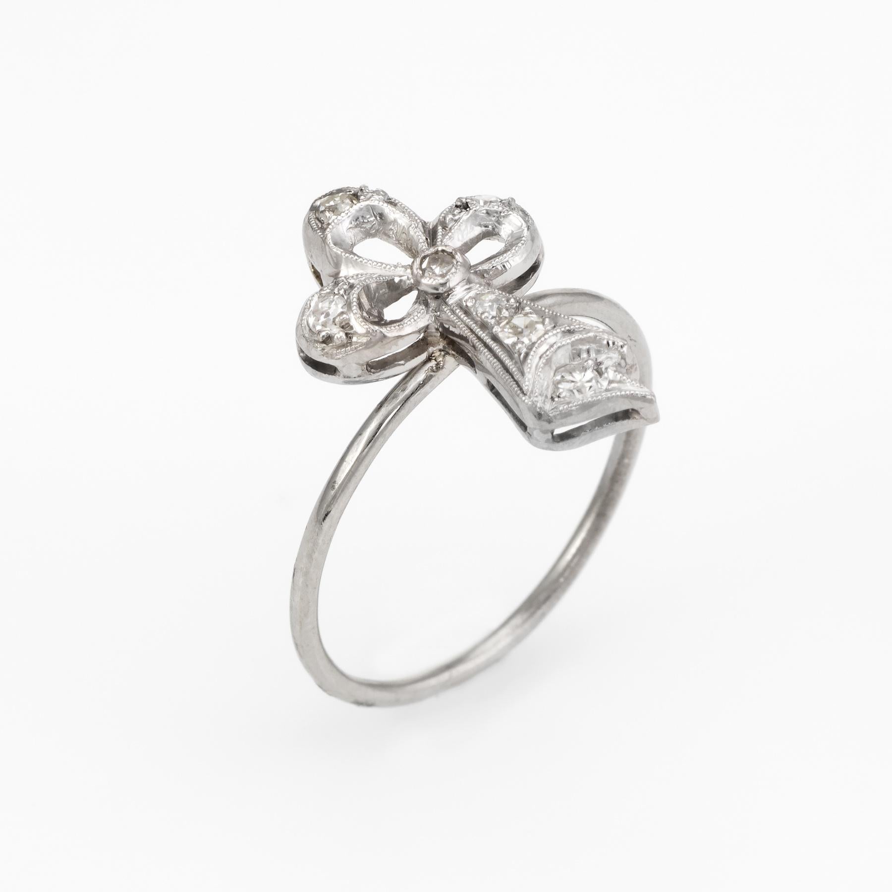 Originally a vintage Art Deco era stick pin (circa 1920s to 1930s), the stylized clover is crafted in 14 karat white gold and platinum. 

The clover is mounted with the original stick pin. Our jeweler rounded the stick pin into a slim band for the