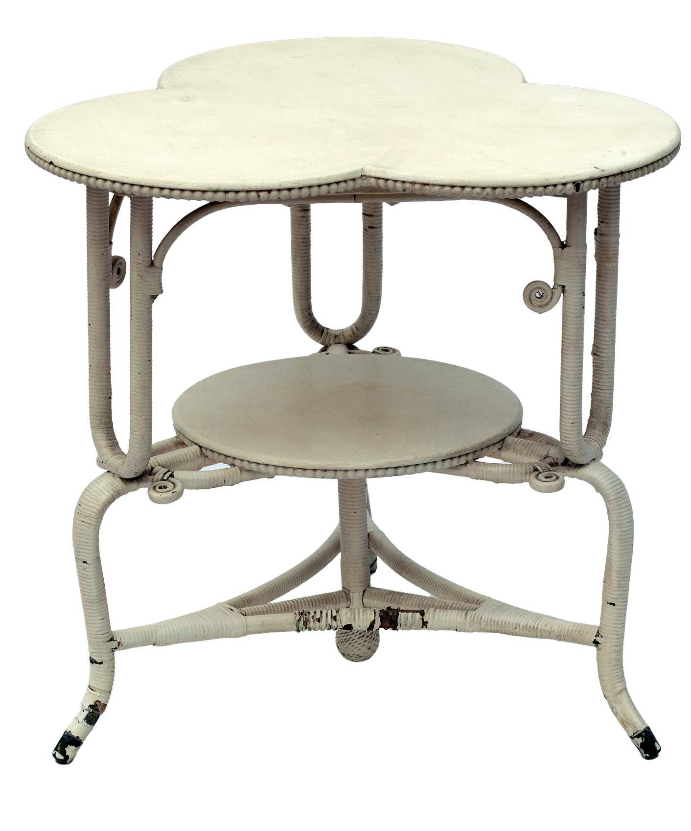 19th century antique two-tiered cloverleaf table with wicker wrapped legs. The table rests on 3 legs.
Old enamel paint., beaded edge.
