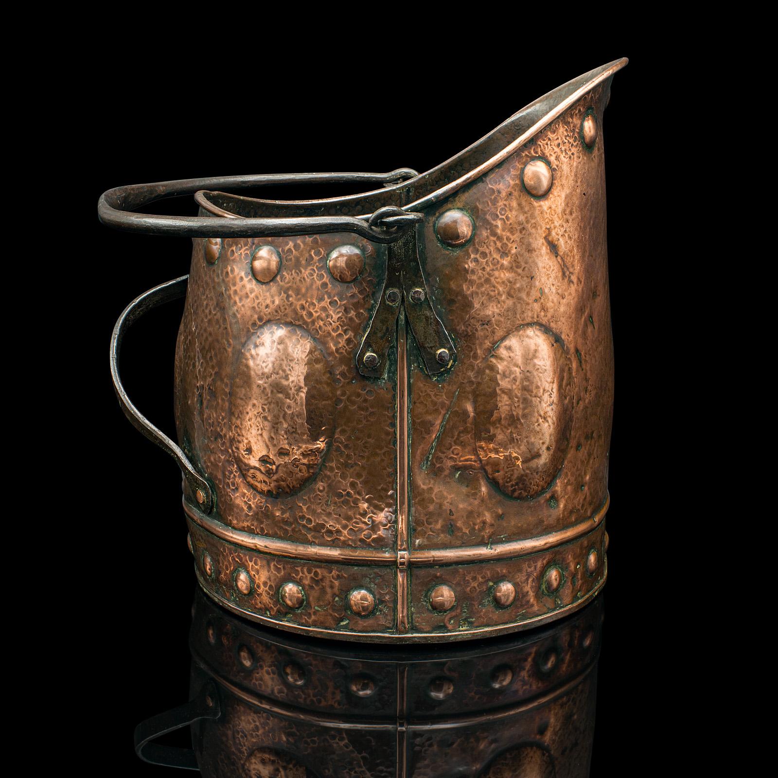 This is an antique coal scuttle. A Scottish, hand-beaten copper fireside bin in Aesthetic Period taste, dating to the Victorian era, circa 1880.

Wonderfully decorative and hand finished - a treat for the fireplace
Displays a desirable aged patina