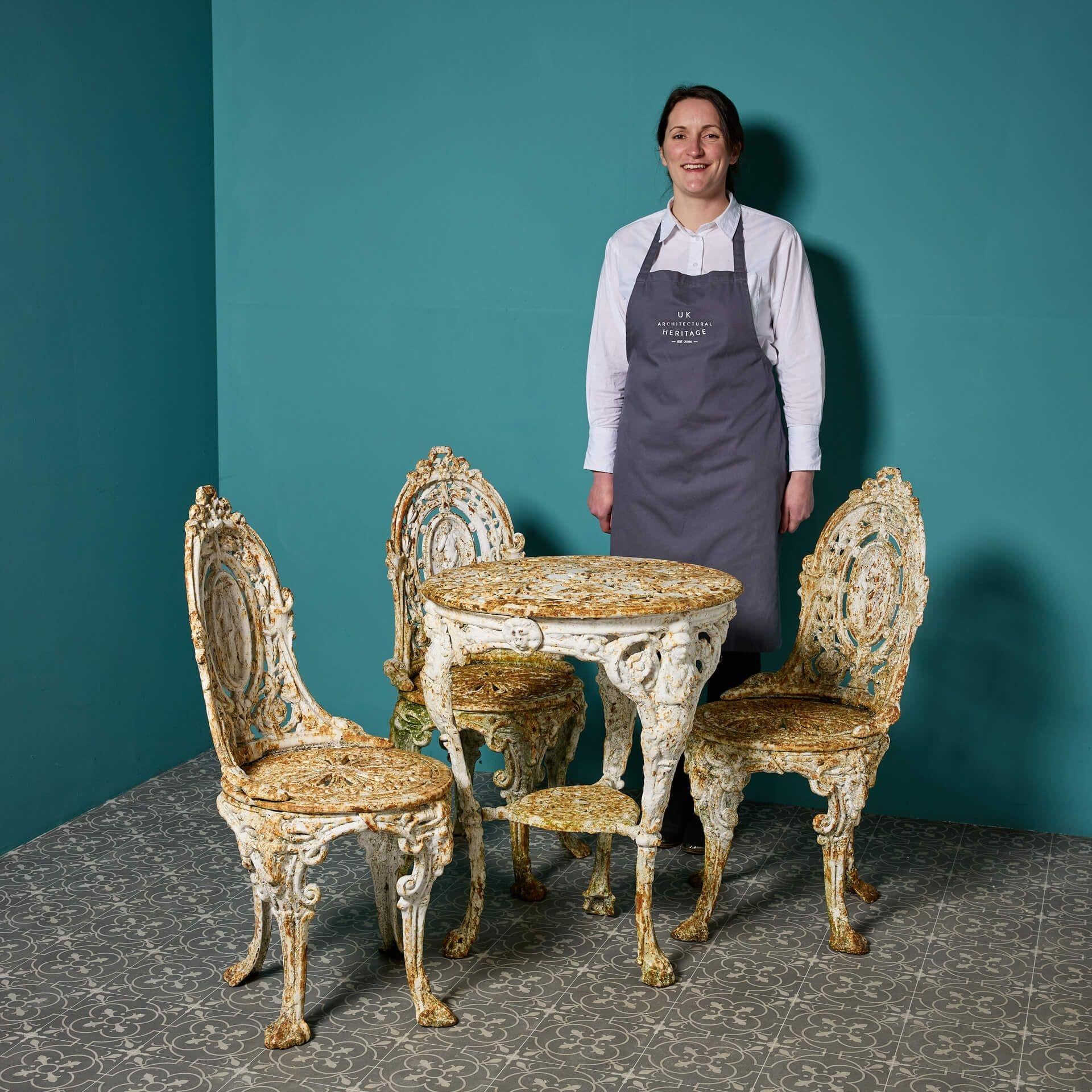 A complete antique ornate garden patio set of a table and three chairs in the manner of Coalbrookdale.

Although small, this set has a beautiful heavily ornate design paired with a desirable distressed finish. If you look closely you'll see an