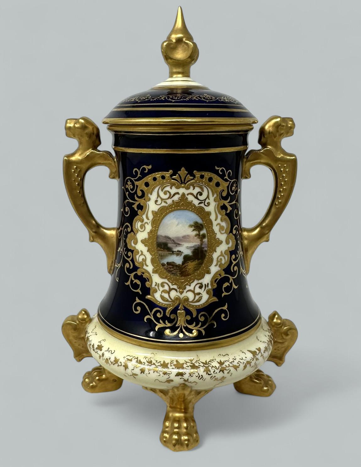 Stunning Hand Painted English Porcelain Coalport Twin Handle Lidded single Vase of Museum quality, hand decorated depicting an English Landscape view. Circa 1910-20.   

The central oval reserve depicts a mountainous view with a central lake, which