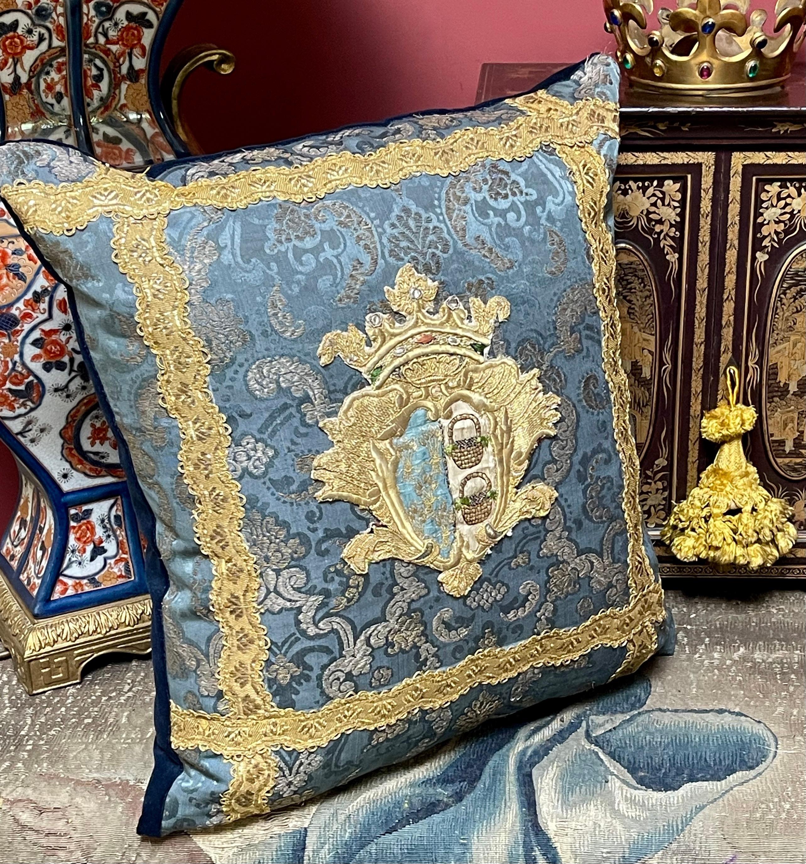ntique Coat of Arms Pillow

Early 18th century Spanish Coat of Arms,  hand embroidered in metal threads and silks. Upon an 18th century blue silk , brocaded with silver metal threads

Finished with 19th century gold metallic braid.   Backed with
