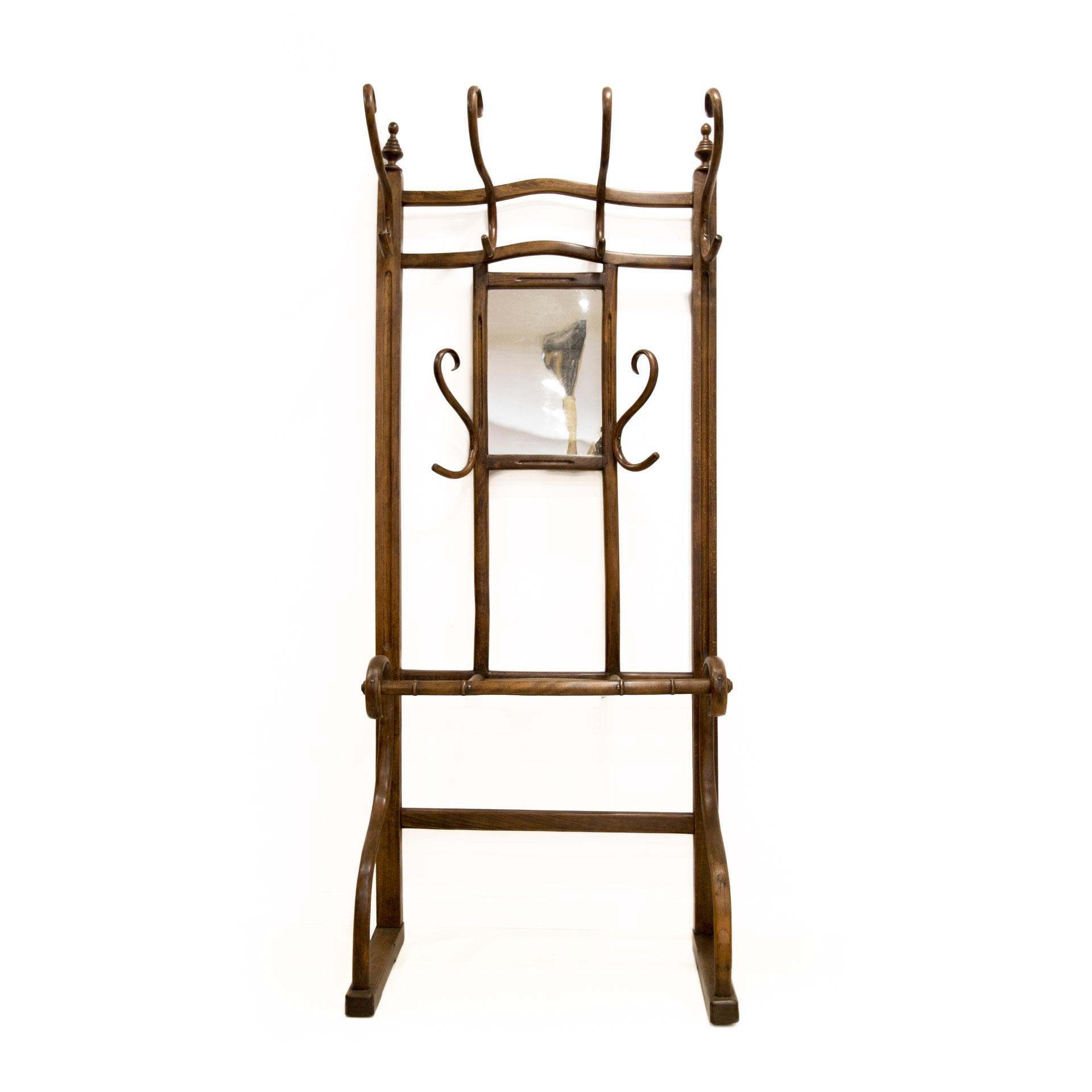 This large coat hanger with a mirror comes from Austria from the beginning of the 20th century. It was made in a technique patented by an outstanding designer and Pioneer of furniture making, Michael Thonet. The innovative design makes the furniture