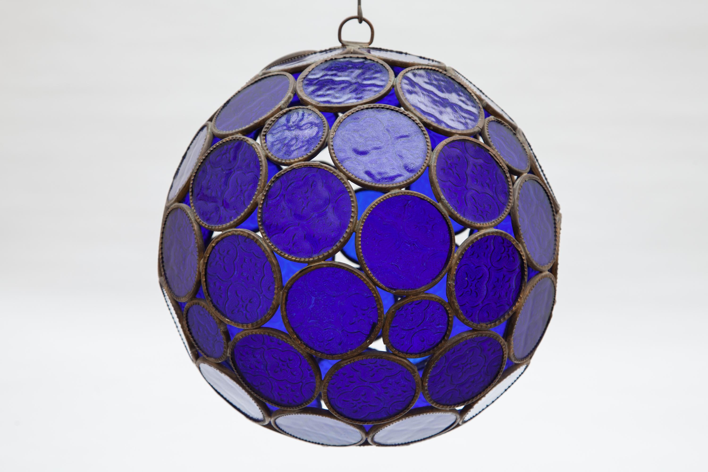 Beautiful antique glass lantern Queen Victorian cobalt blue press glass bowl, each glass-cirkel is framed with a metal hammered decorated round frame each connect together to a bowl. With sunlight already gives nice nuances.
Dimension: 30 cm D.