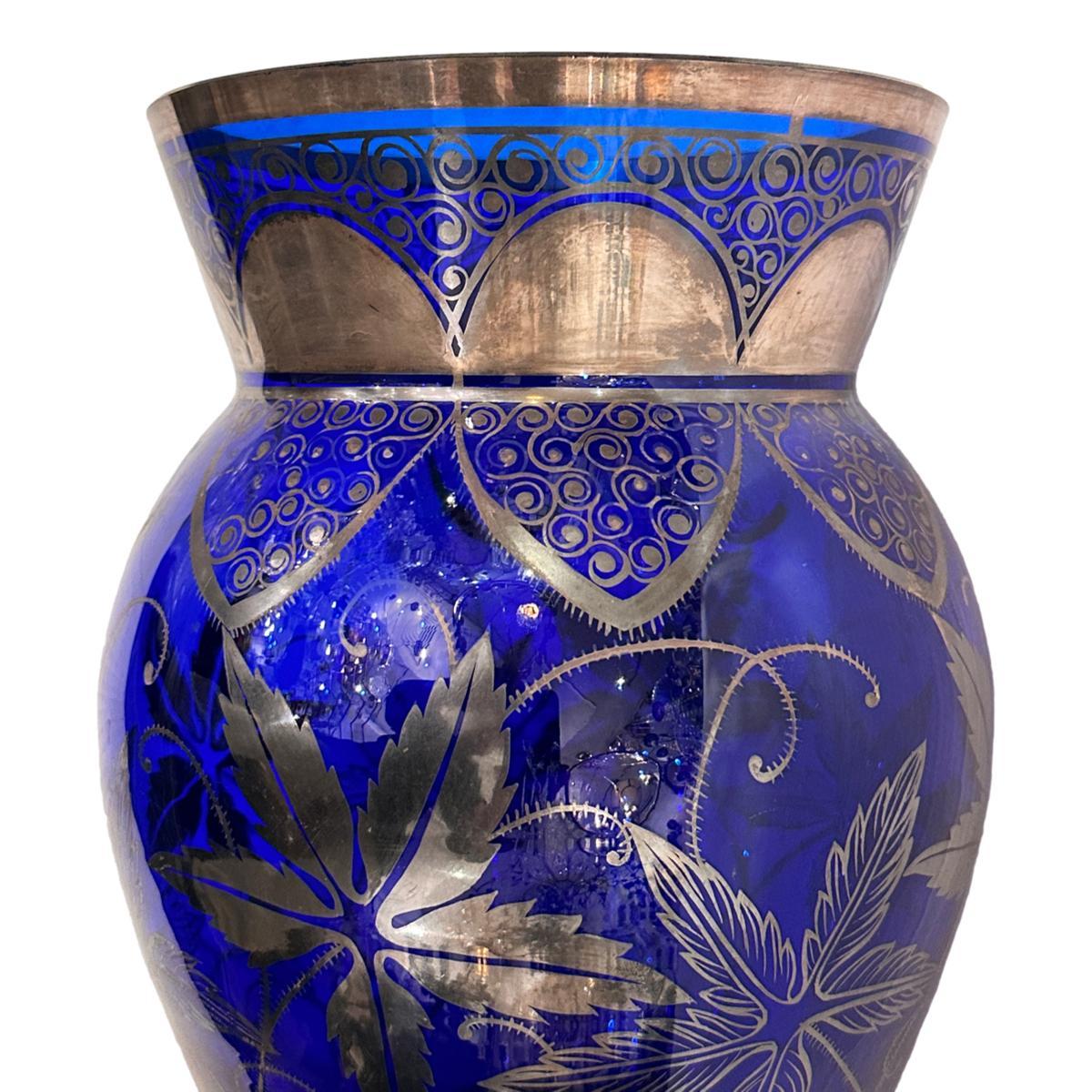 Vaso in vetro blu cobalto francese del 1920 circa con decorazione a fogliame in argento.

Misure:
Altezza: 13