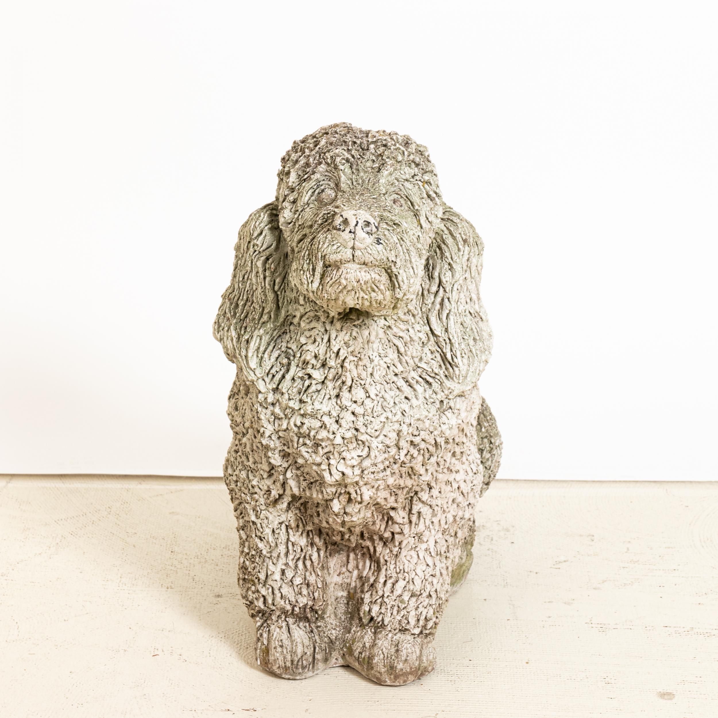 Unique cast stone garden statue in the shape of a cocker spaniel dog. Made in England in the early 20th century, this charming statue a playful element to add to the landscape. Nice texture at the curly coat of the dog. Good condition, weathered