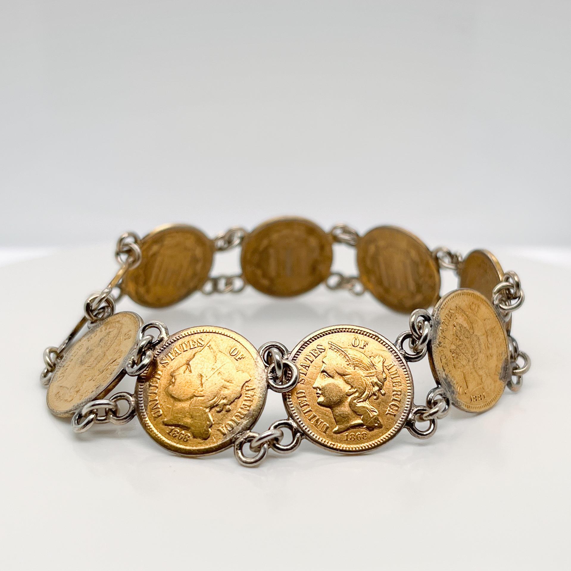 A very fine antique coin bracelet.

Comprised of American three-cent coins attached with silver jump rings.

The coins have been embellished with gilding.

Simply a great coin bracelet!

Date:
20th Century

Overall Condition:
It is in overall good,