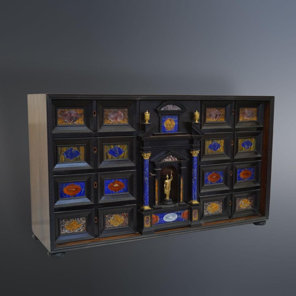 Monedero antiguo de madera ebonizada con raras piedras semipreciosas y bronces dorados, siglo XVIII. Dimensiones: 71x122x36cm Buen estado - usado con pequeños signos de envejecimiento y manchas. Monetiere Antico il legno ebanizzato con rare pietre