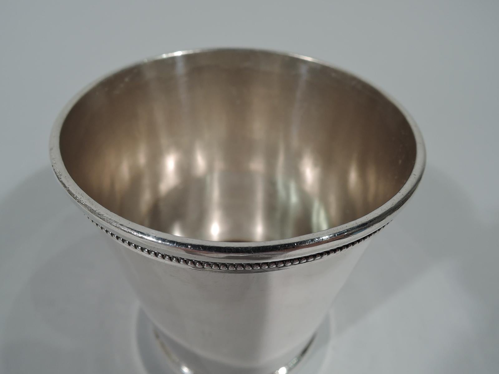 Coin silver mint julep cup. Made by Eugene Jaccard in St Louis. Straight and tapering sides. Beaded rim and foot between molded borders. Serviceable antique barware by a regional maker, who was active circa 1855-1871. Weight: 5.6 troy ounces.