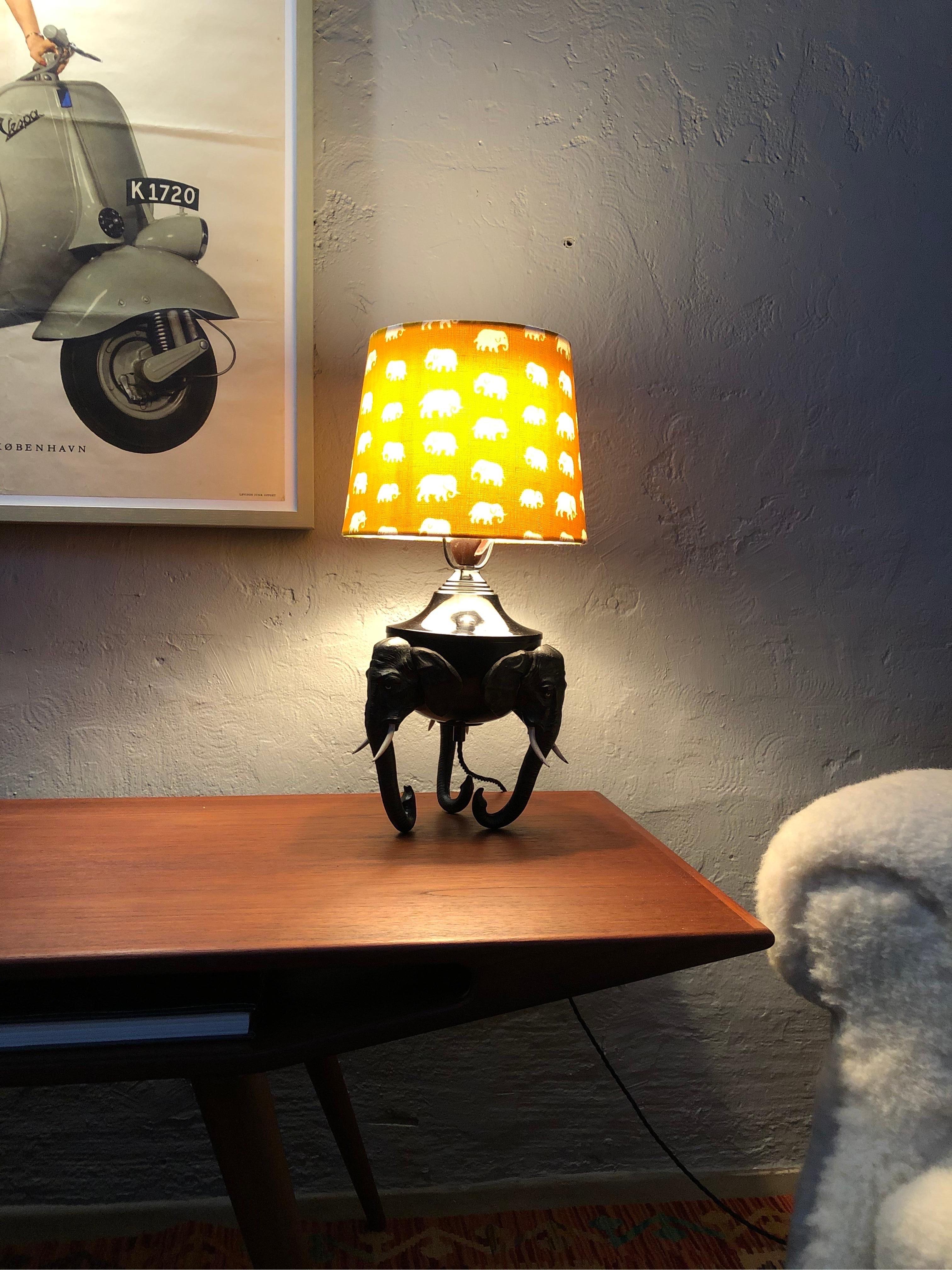 Rare antique elephant lamp from the early 20th century.
Raised on 3 elephant heads.
Original cold painted bronze with a great patina and look to the surface.
Original Bakelite bulb holder rewired with black twisted cloth flex and grounded.
Lampshade