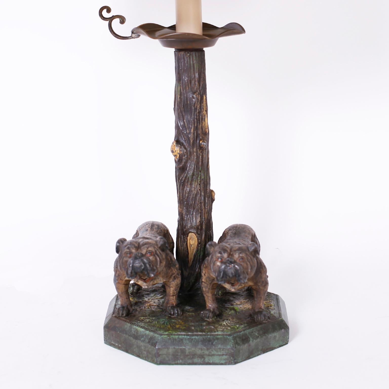 Beeindruckende antike Tischlampe aus Bronze mit Kaltlackierung und erworbener Patina, die zwei Bulldoggen und einen Baum auf einem achteckigen Sockel darstellt.