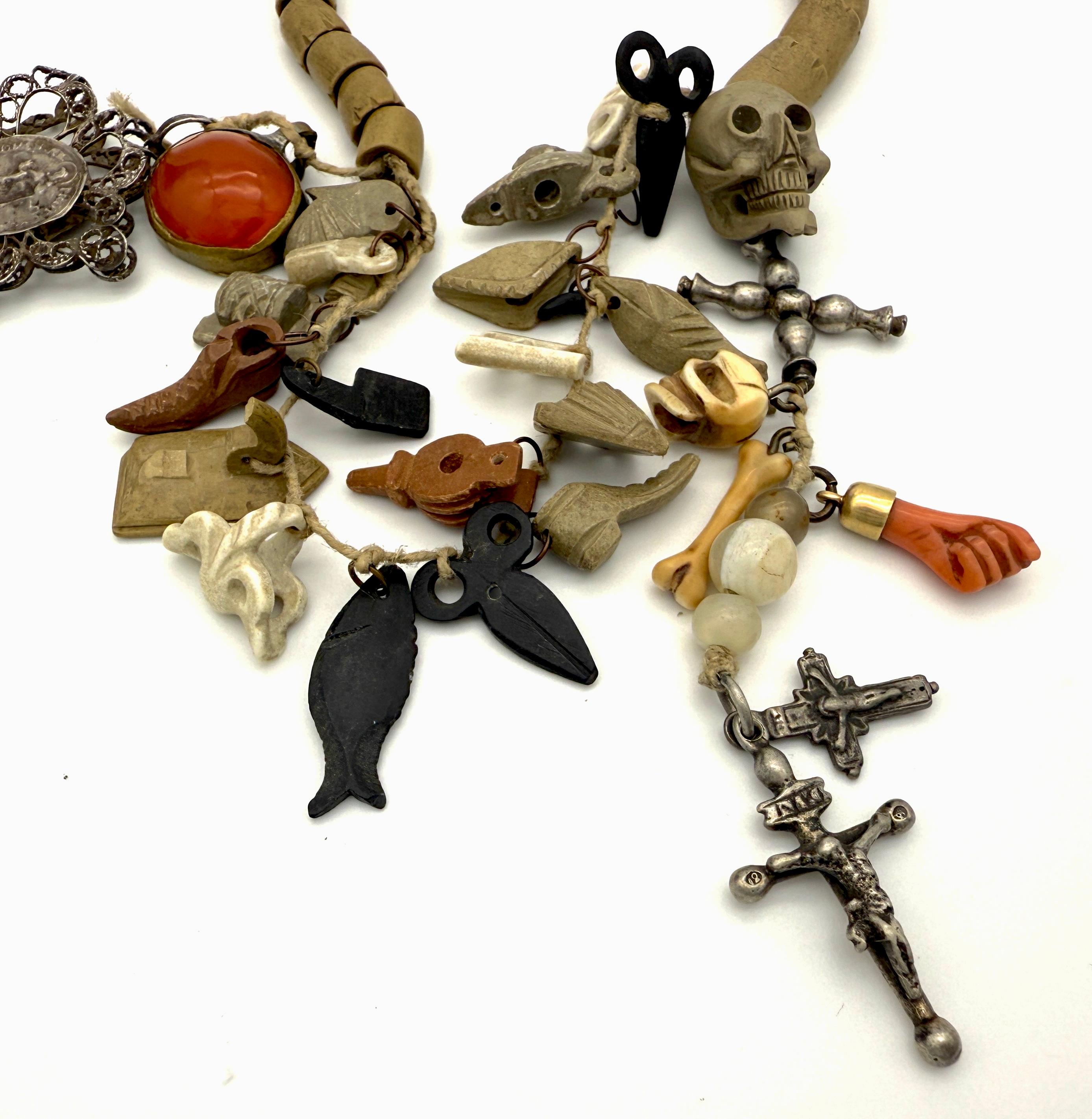 This collection of crosses, charms,amulets and beads was created in Italy in the second quarter of the nineteenth century using some elements of an earlier date. 
Part of this collection is made up from carved lava segments used to to create