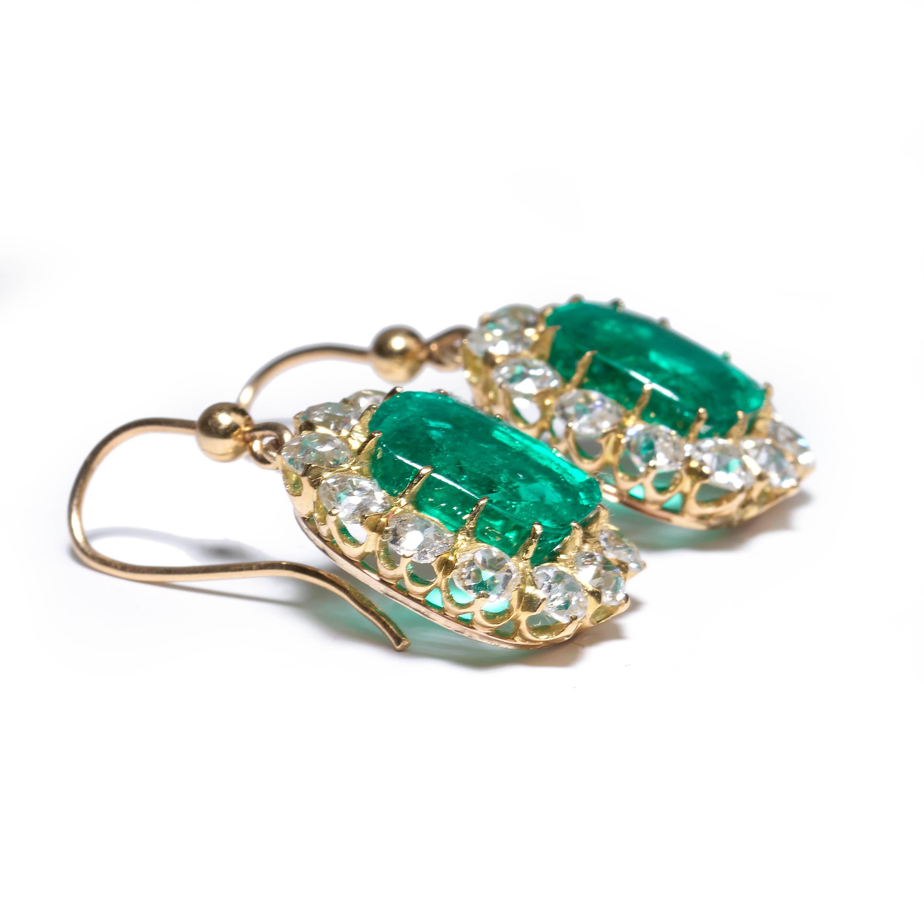 A pair of Victorian drop earrings, comprised of emerald and diamond clusters, centrally set with cushion-shaped emeralds of Colombian origin, weighing 4.94ct and 5.14ct each, surrounded by twelve old-cut diamonds, weighing an estimated total of