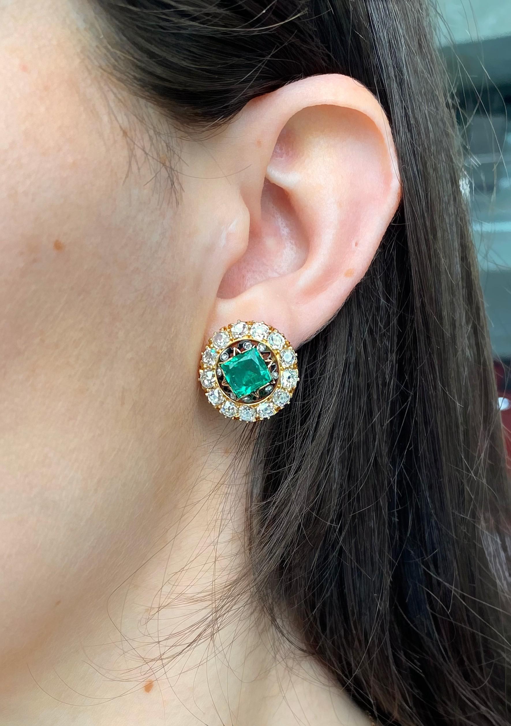 A pair of antique Columbian emerald and diamond cluster earrings, set with rectangular scissor-cut Columbian emeralds, weighing approximately 1.50ct each, in gold, pinched, star shape settings, with rose-cut diamonds set, in silver,  between the