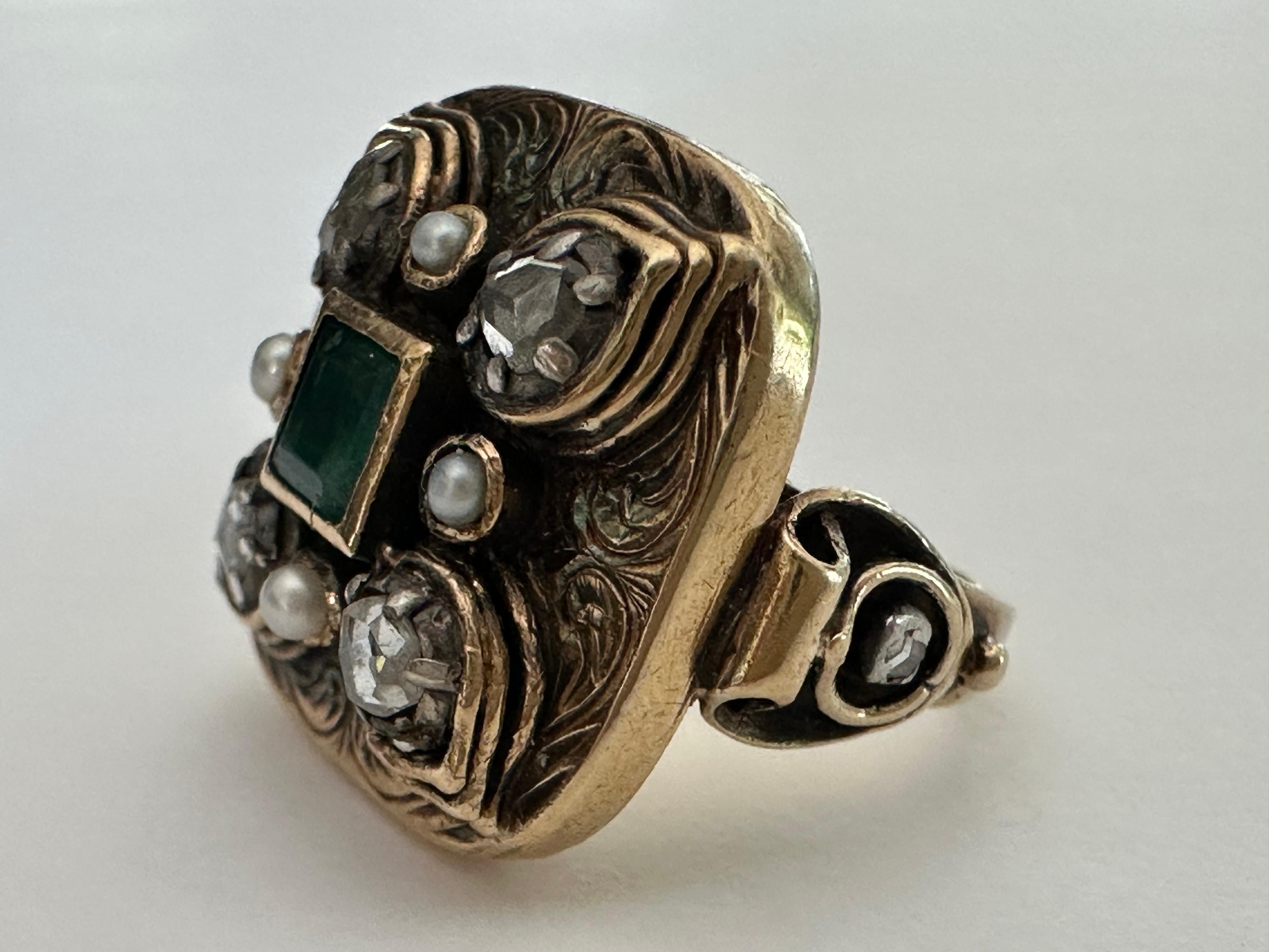 Dieser quadratische antike Ring, der wahrscheinlich aus dem frühen 19. Jahrhundert stammt, zeigt einen in der Lünette gefassten kolumbianischen Smaragd im Quadratschliff, der von vier kleinen Saatperlen und vier Diamanten im Rosenschliff in einem