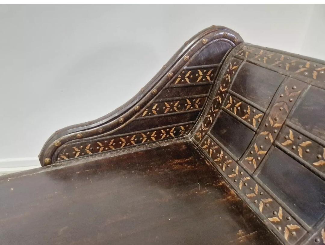 Cette exquise chaise longue coloniale ancienne est une pièce unique et rare qui respire l'élégance et la sophistication. Fabriquée en bois exotique de haute qualité avec une finition laquée, cette chaise longue est un ajout parfait à n'importe