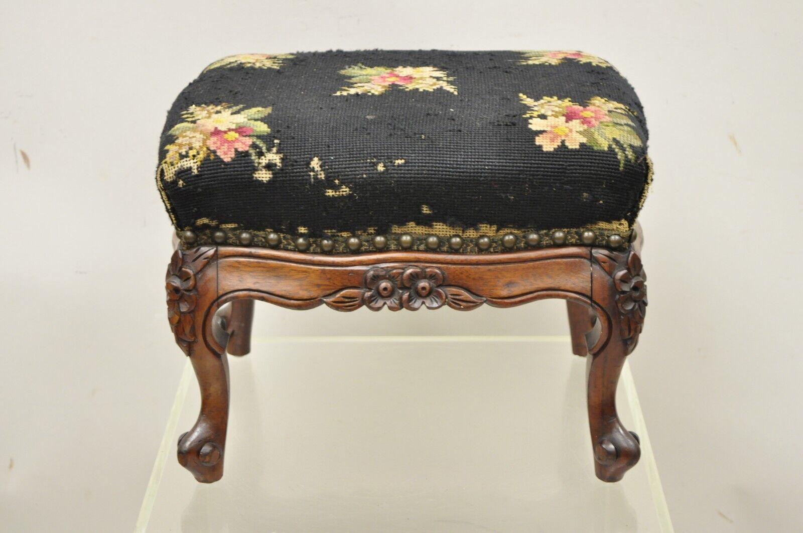 Antique Colonial furniture mahogany needlepoint footstool ottoman stool. Item features a solid mahogany frame, floral carved details, needlepoint seat, original label, cabriole legs, very nice antique item circa early 1900s. Measurements: 11