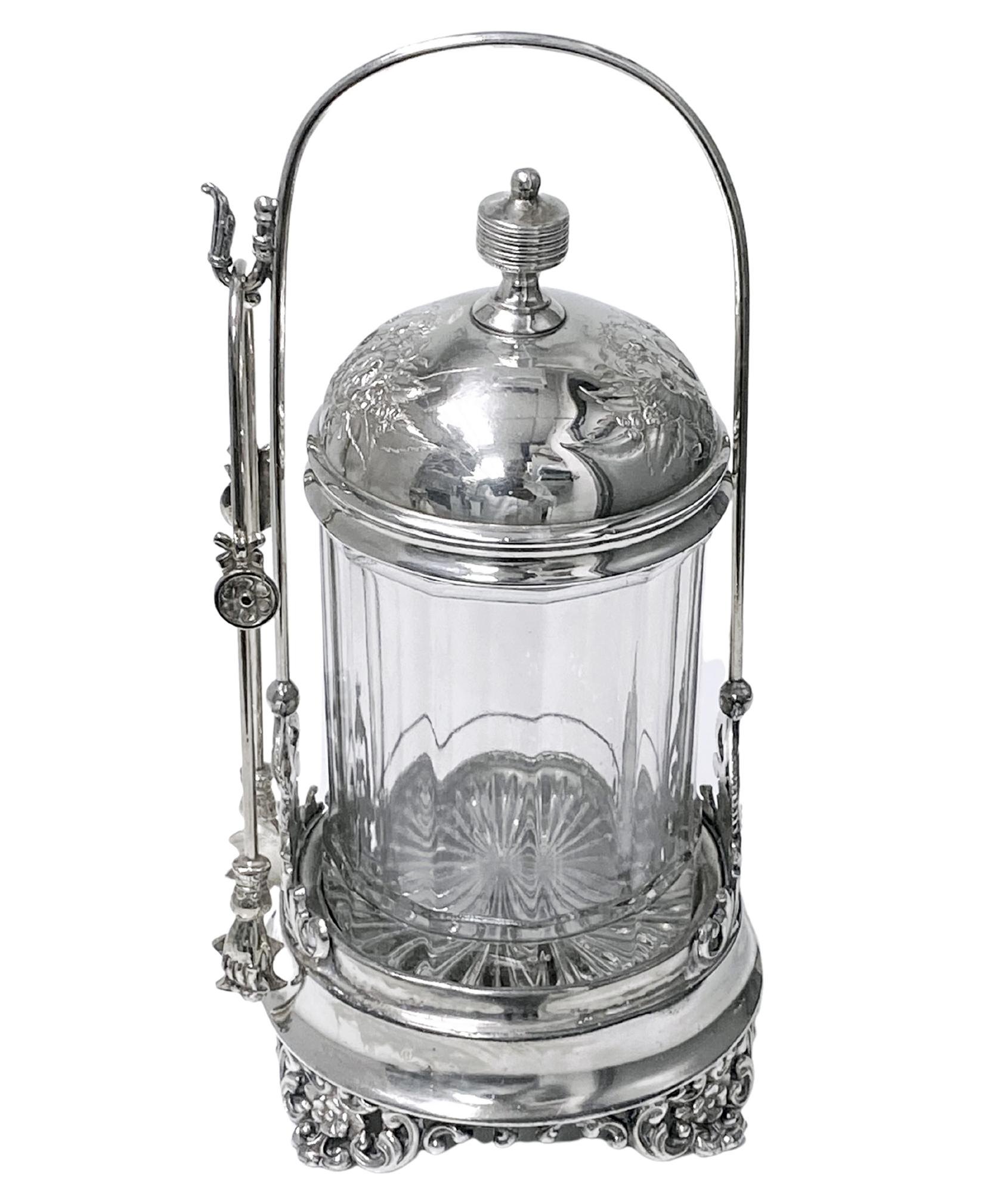 Antique Colonial Quadruple Silver plate Pickle Castor with Tongs, C.1890. Good condition, paneled glass container, footed frame base with pierced scroll foliage supports conforming in design to frame of glass lid with ribbed finial Signed on
