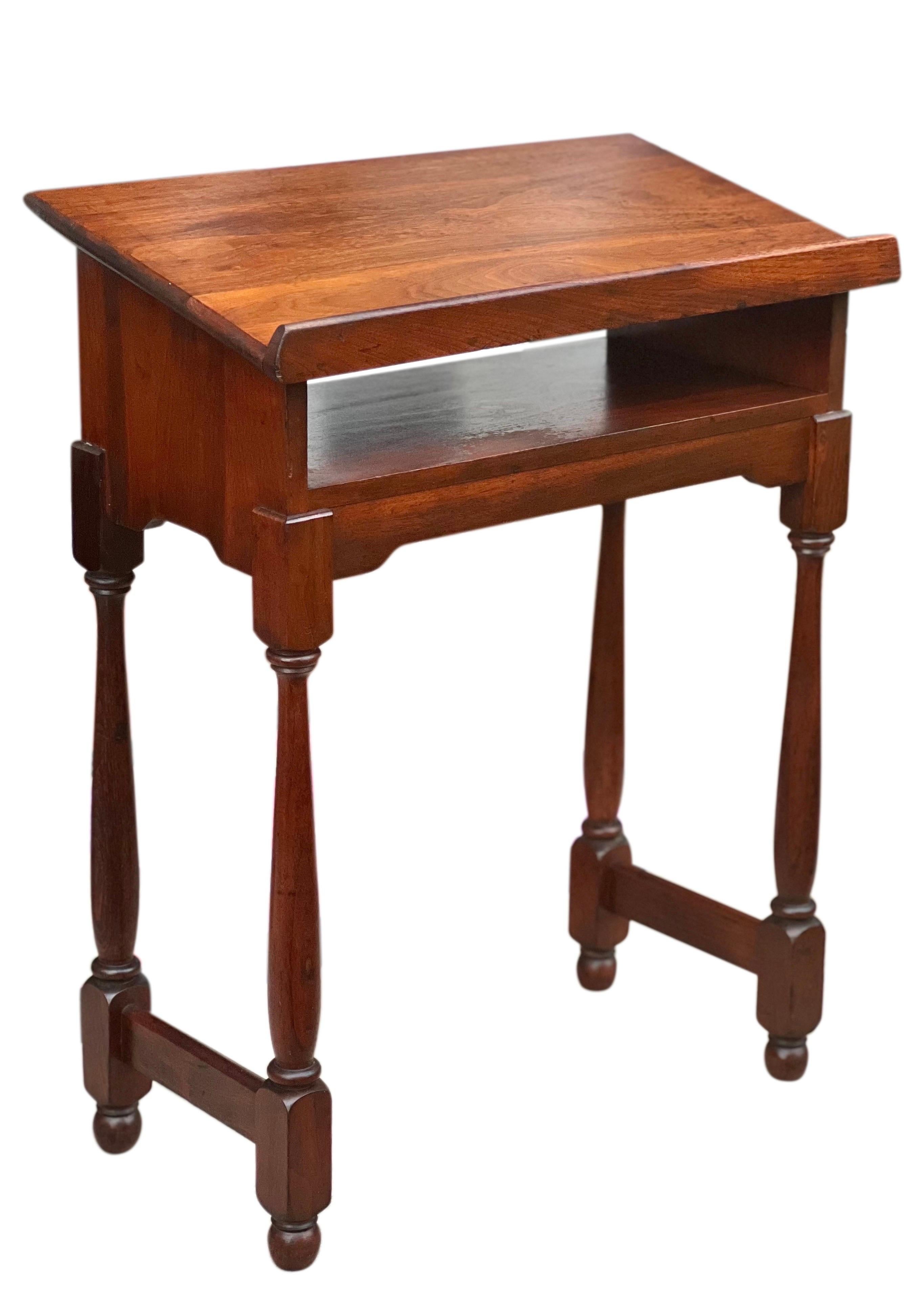 Antique Colonial Revival small walnut lectern, c. 1910-20.

Wonderful lectern with rich walnut grain features classic slanted top, elegant turned spindle legs and lower open shelf. Lovely in a room or entry way to display a beautiful book, album or