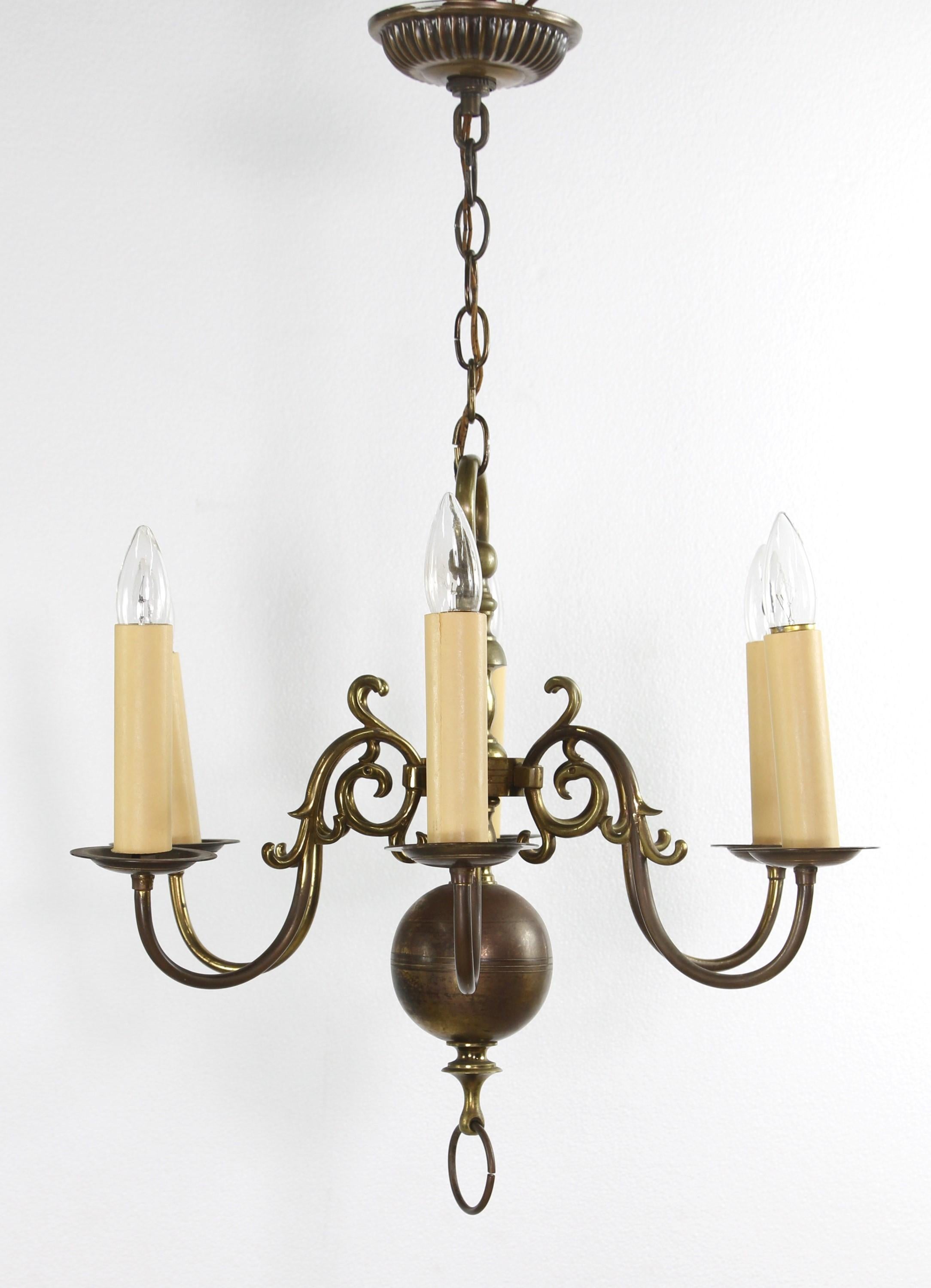 Petite cast brass Williamsburg chandelier with polished brass and warm brass patina and six candlestick arms. This takes six standard E26 sockets. Cleaned and restored. The price includes restoration. Please note, this item is located in our