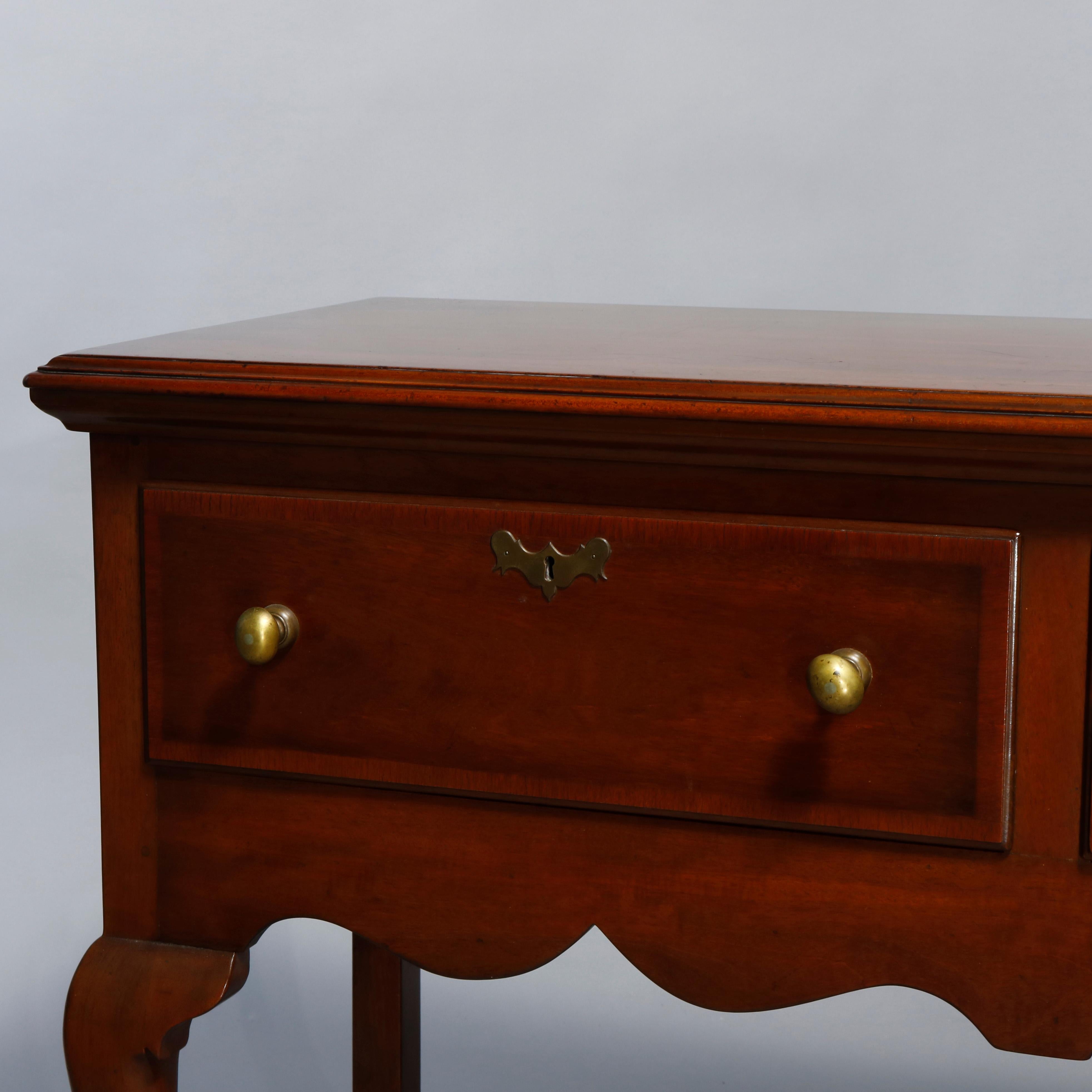 An antique Colonial Williamsburg Kittinger Queen Anne style server offers mahogany construction with three crossbanded drawers over shaped skirt and raised on cabriole legs, maker mark as photographed, 20th century

Measures: 34