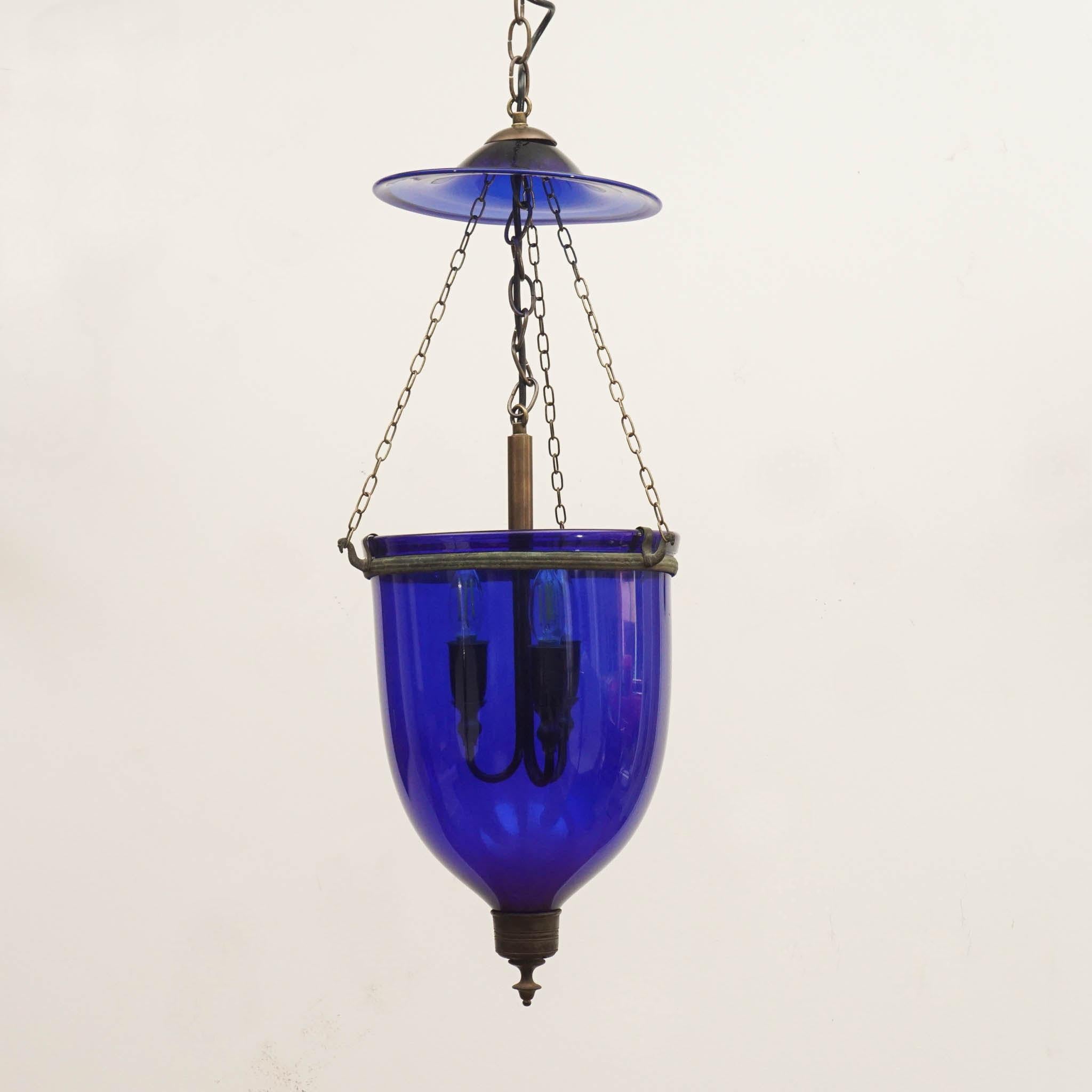 Three different color bell jar lanterns with brass details. Stunning pigment like cobalt can be dated back as far as 1802, making these ceiling fixtures even more extraordinary. 

Measurements: 
Height: 36