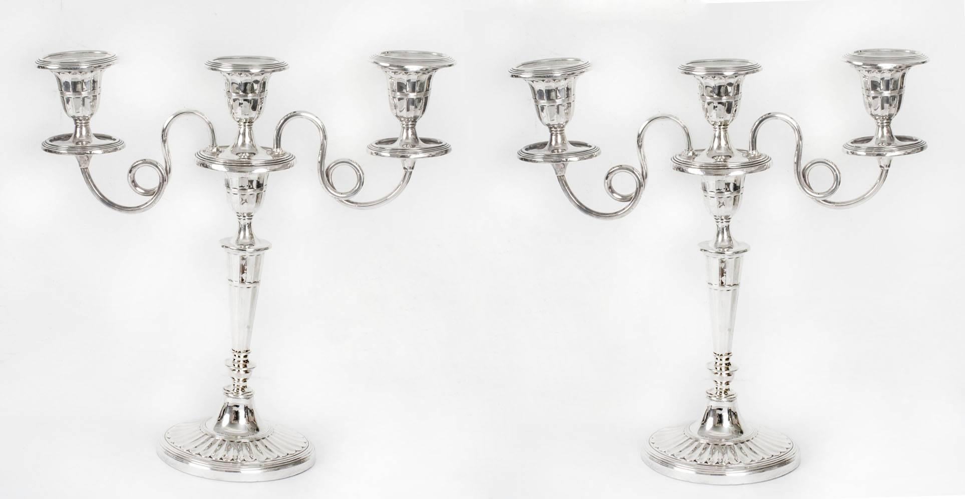 This is an exquisite set of four table lights comprising a pair of Edwardian English antique sterling silver candlesticks with hallmarks for London, 1902 and the makers mark of the renowned silversmith Wiliam Huttons & Sons, together with a pair of