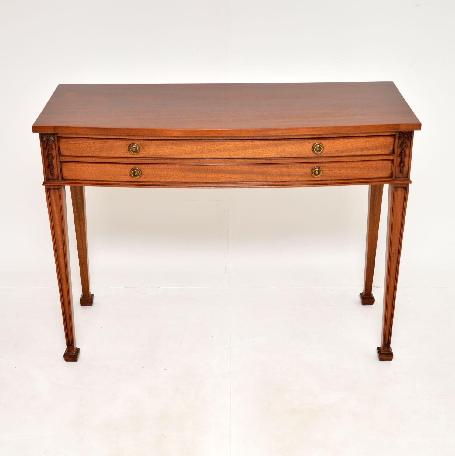 A beautiful and elegant Sheraton style antique console / server table. This was made in England, it dates from around the 1900-1920 period.
It is very well made, with a beautiful bow front design and fine carving on the corners. The drawers have