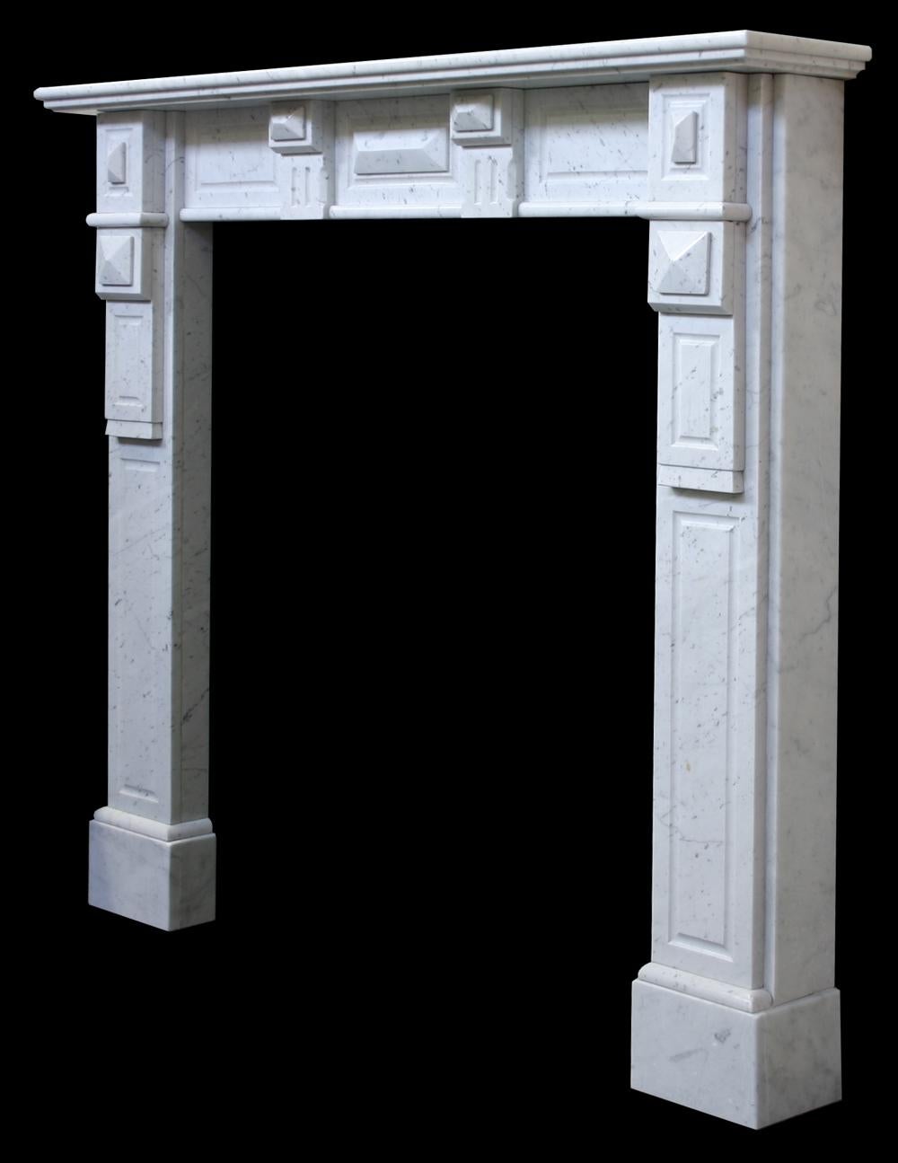 Antique continental Carara marble fire surround with fluted legs terminating in geometric corbels decorated with lozenges. The frieze has two simple corbels also decorated with lozenges, circa 1900.