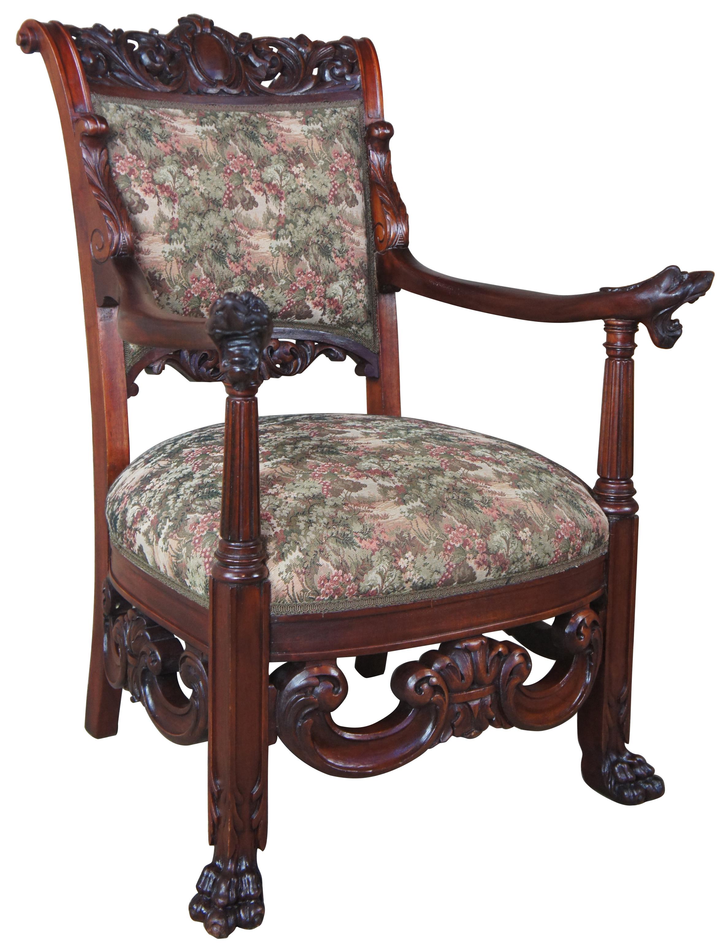 Mid-19th century continental armchair. Made from mahogany with scrolled and carved back leading to figural arms featuring dog head carvings. Each arm is supported by a fluted and tapered column leading to paw feet. Chair is covered with an Aubusson