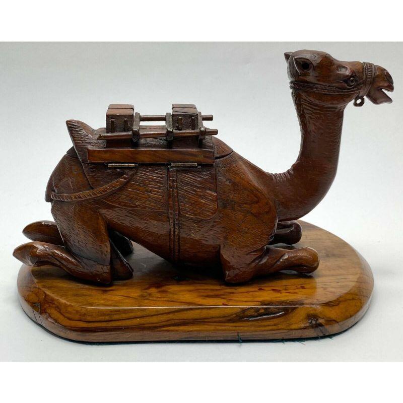 Antique continental hand carved novelty ink stand & pen tray camel formed.

A finely hand carved ink stand modeled as a sitting camel circa early 20th century. The hump opens to Revel two glass lined ink wells to the forefront and a carved inset