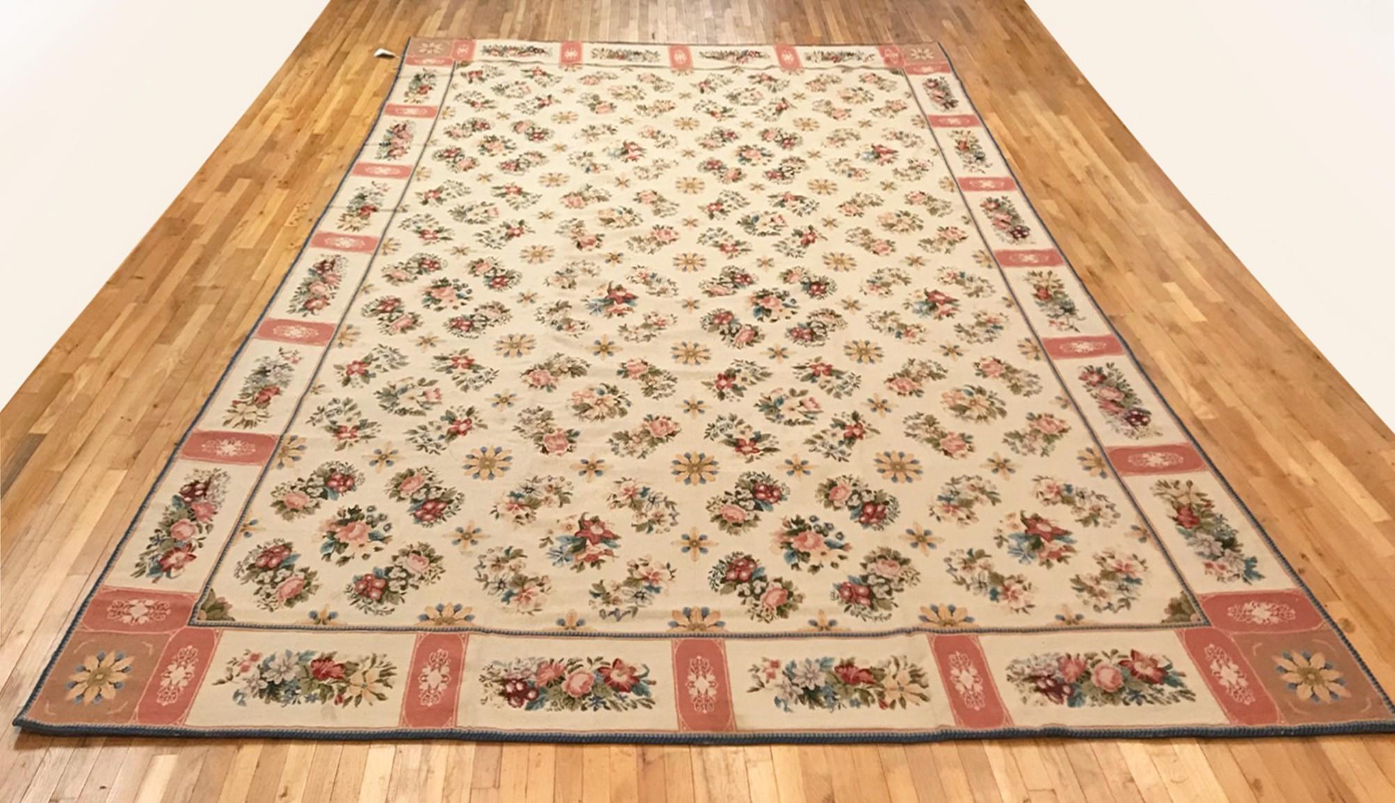 Antique Continental Needlepoint Rug, in Large size, circa 1900.

A one-of-a-kind antique Continental needlepoint rug, hand-knotted with soft wool pile. This lovely hand-knotted rug features a repeating floral design allover the ivory central