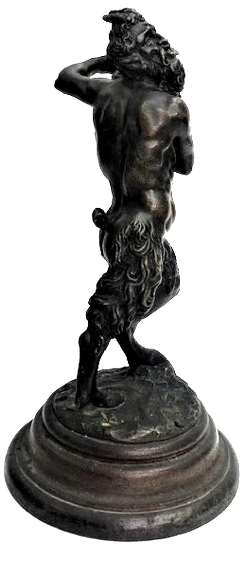 Probably Italian, 19th Century patinated bronze candlestick in form of a dancing Fawn holding a candle-vessel in his hands, on its original wood base.