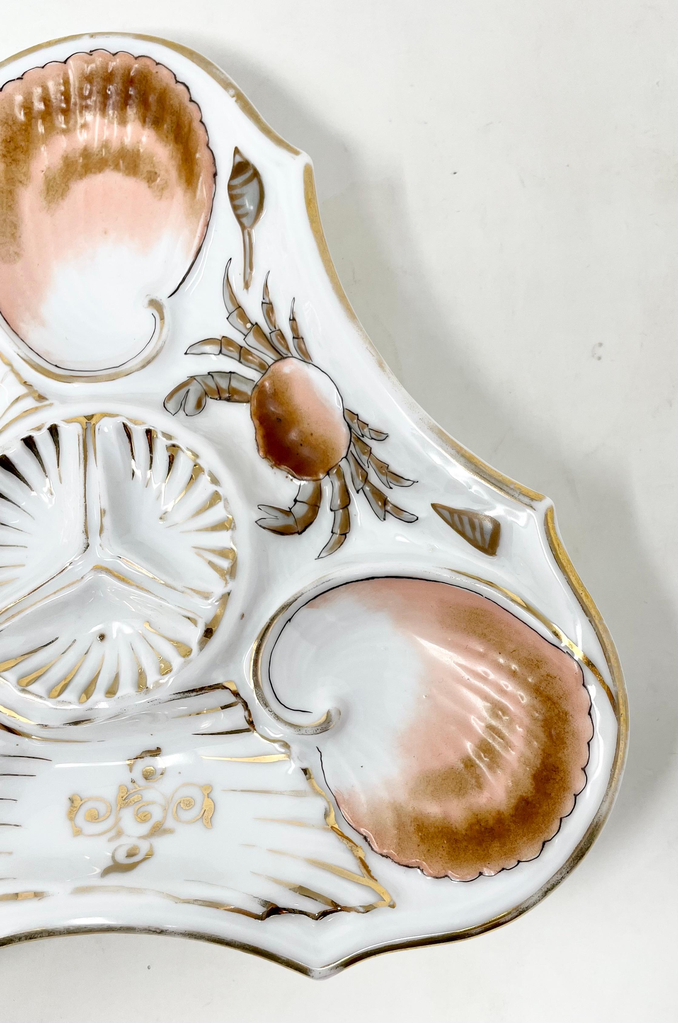 Rare antique continental porcelain hand-painted triangle design oyster plate, circa 1880-1890s.
Pretty hand-painted crab with sea-shells in peach, umber and gold colors.