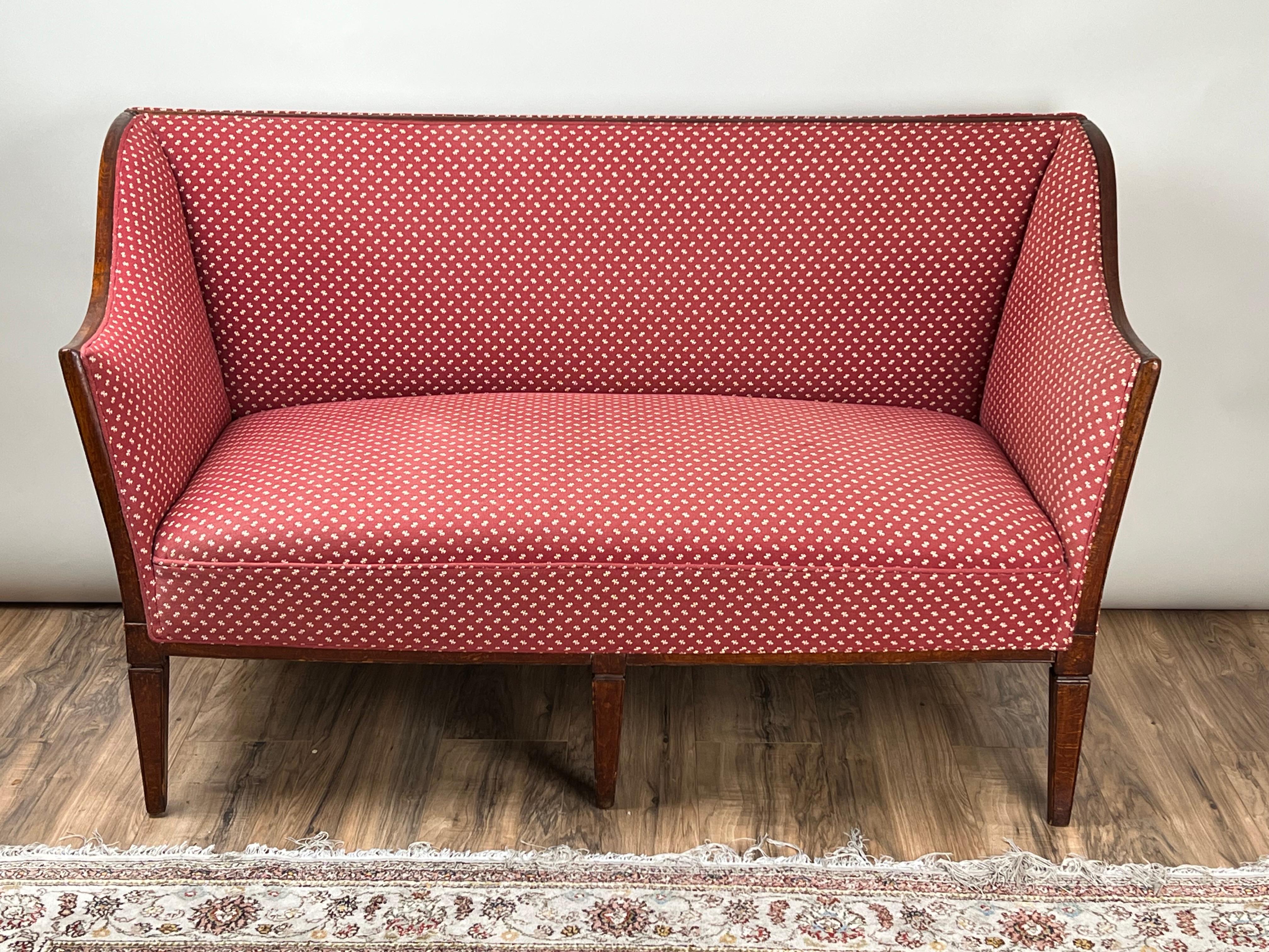 This refined early 19th century Continental settee, possibly Austrian in origin, reflects the elegant simplicity of neoclassical seating furniture of the period. The frame is crafted in mahogany with clean, tapering legs and slightly splayed back
