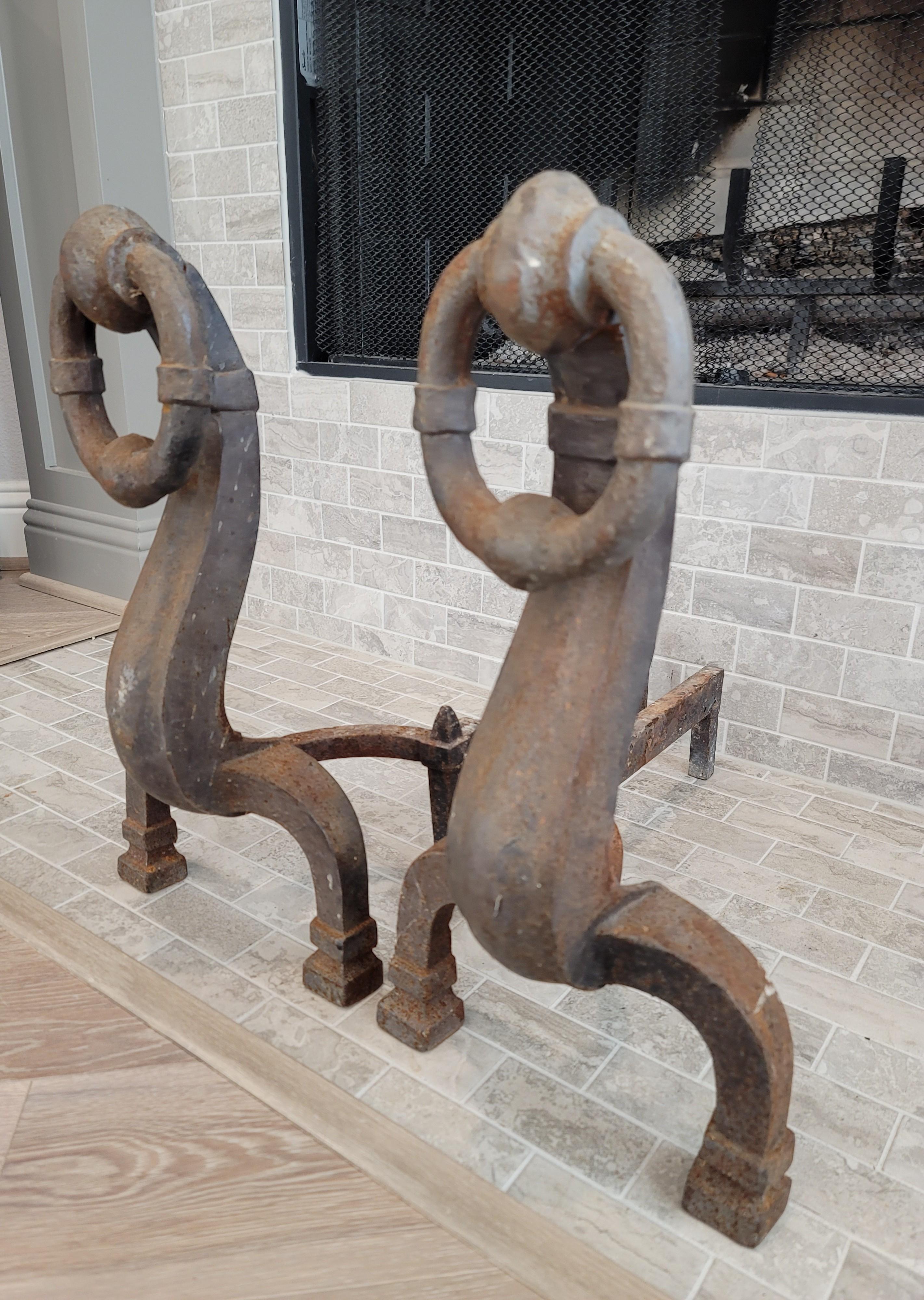 A pair of large antique Continental hand forged iron fireplace andirons / firedogs. 

Dating to the 19th century, featuring traditional old world European craftsmanship, Arts and Crafts Movement period styling with medieval and folk influence,