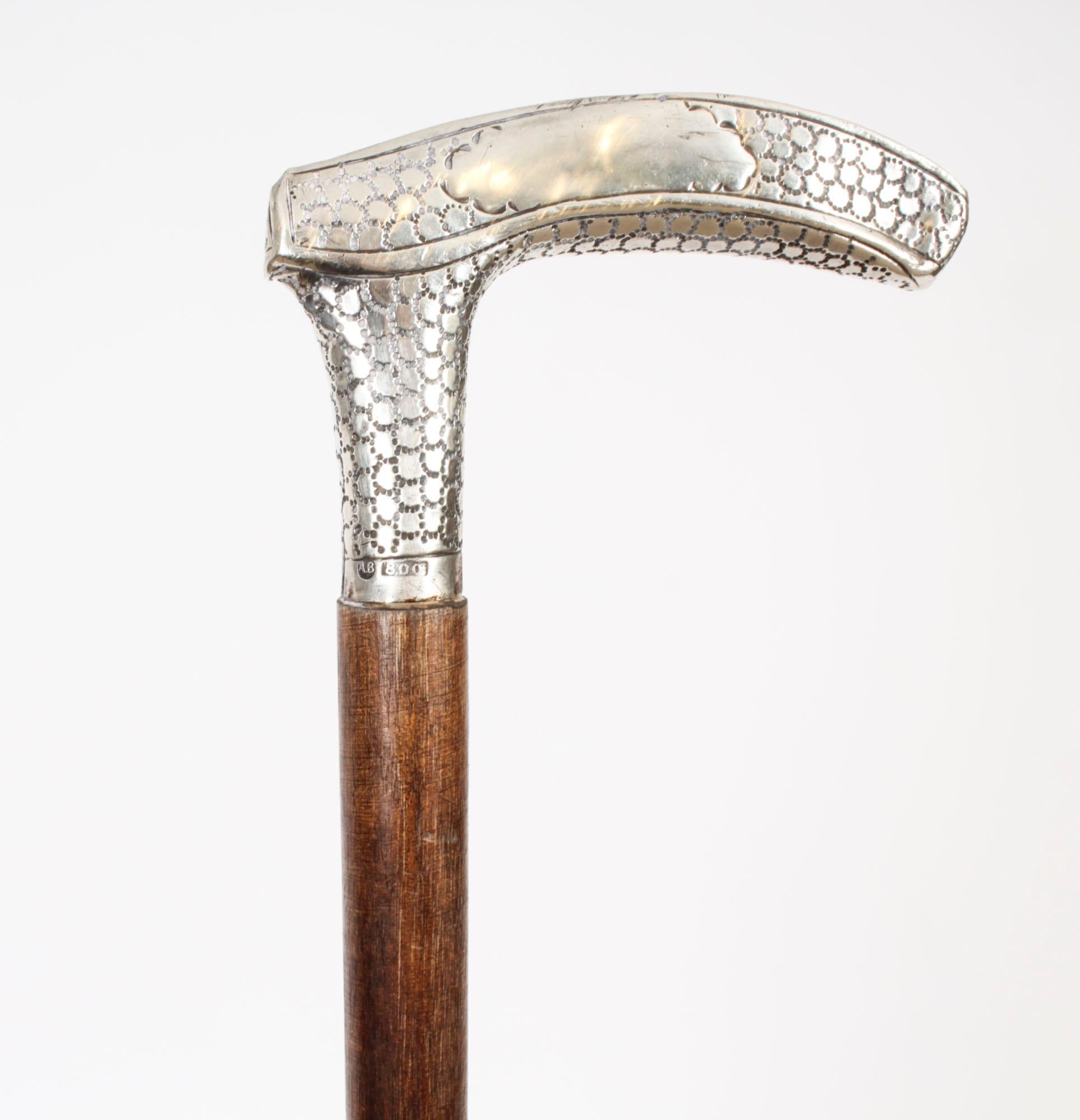 This is a beautiful antique continental silver handeled walking stick marked AB 800, circa 1880 in date
 
The striking stick features an ornate silver Crutch handle featuring a profusely embossed dotted design marked, on a gentle tapering malacca