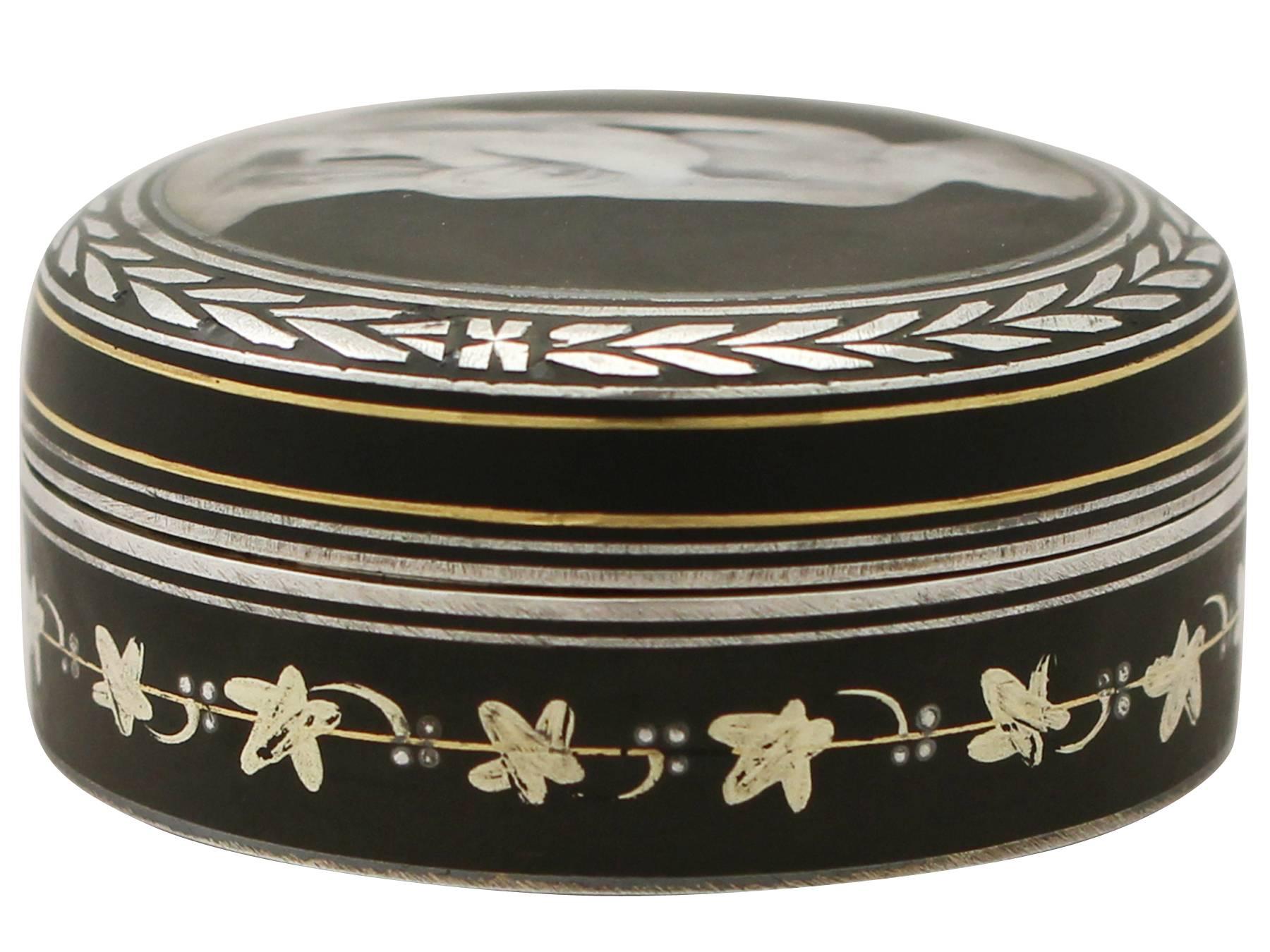 A fine antique continental sterling silver and transfer printed box; part of our continental silverware collection

This antique continental sterling silver and transfer printed box has a cylindrical form.

The body is encircled with inlaid gold and
