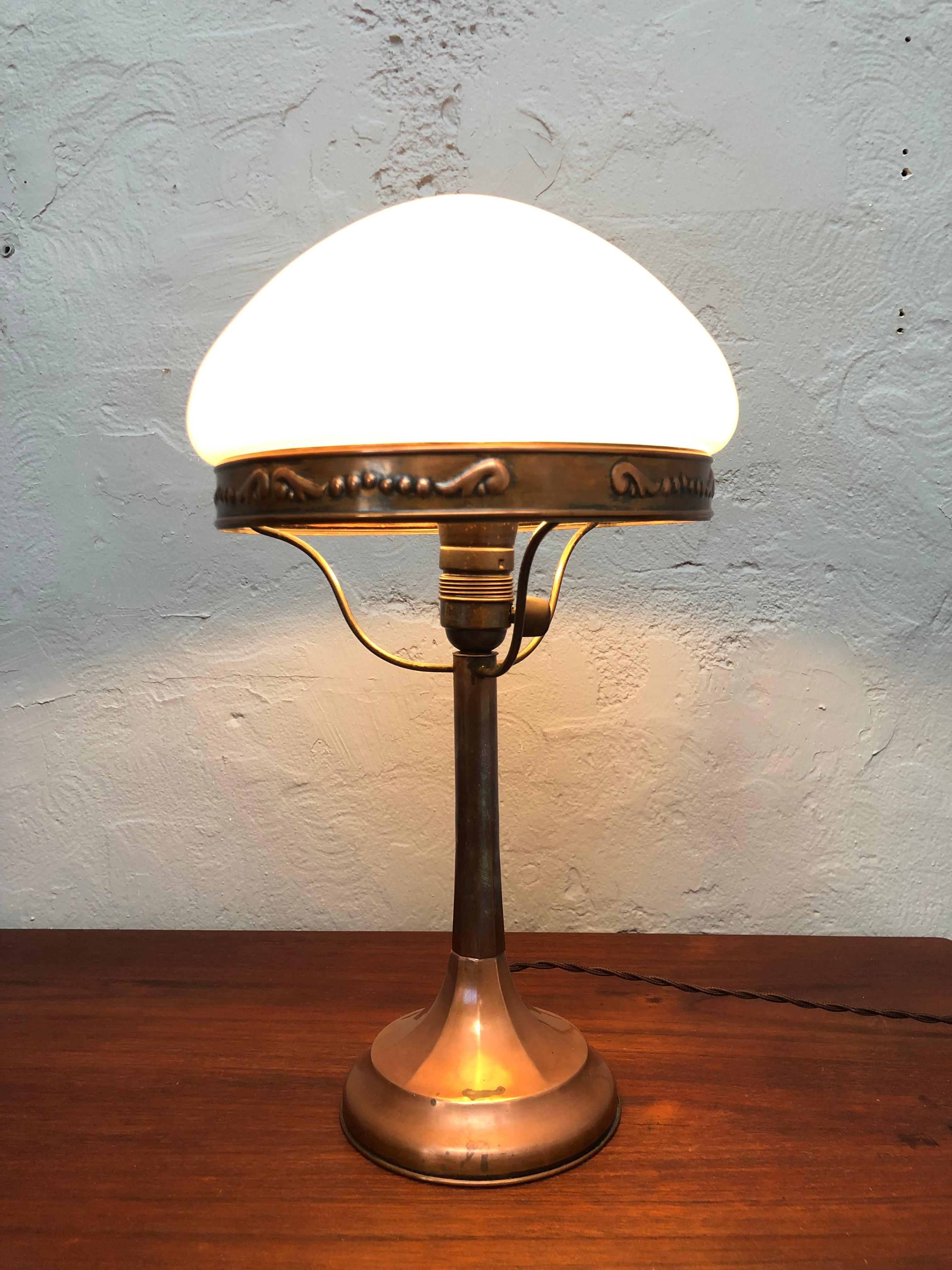 A very elegant antique copper art deco Strindberg lamp from the 1930s. 
Stands completely original from the hand blown white opaline glass defuser to the copper bulb holder with on off switch that is still in fine working order. 
Unpolished surface