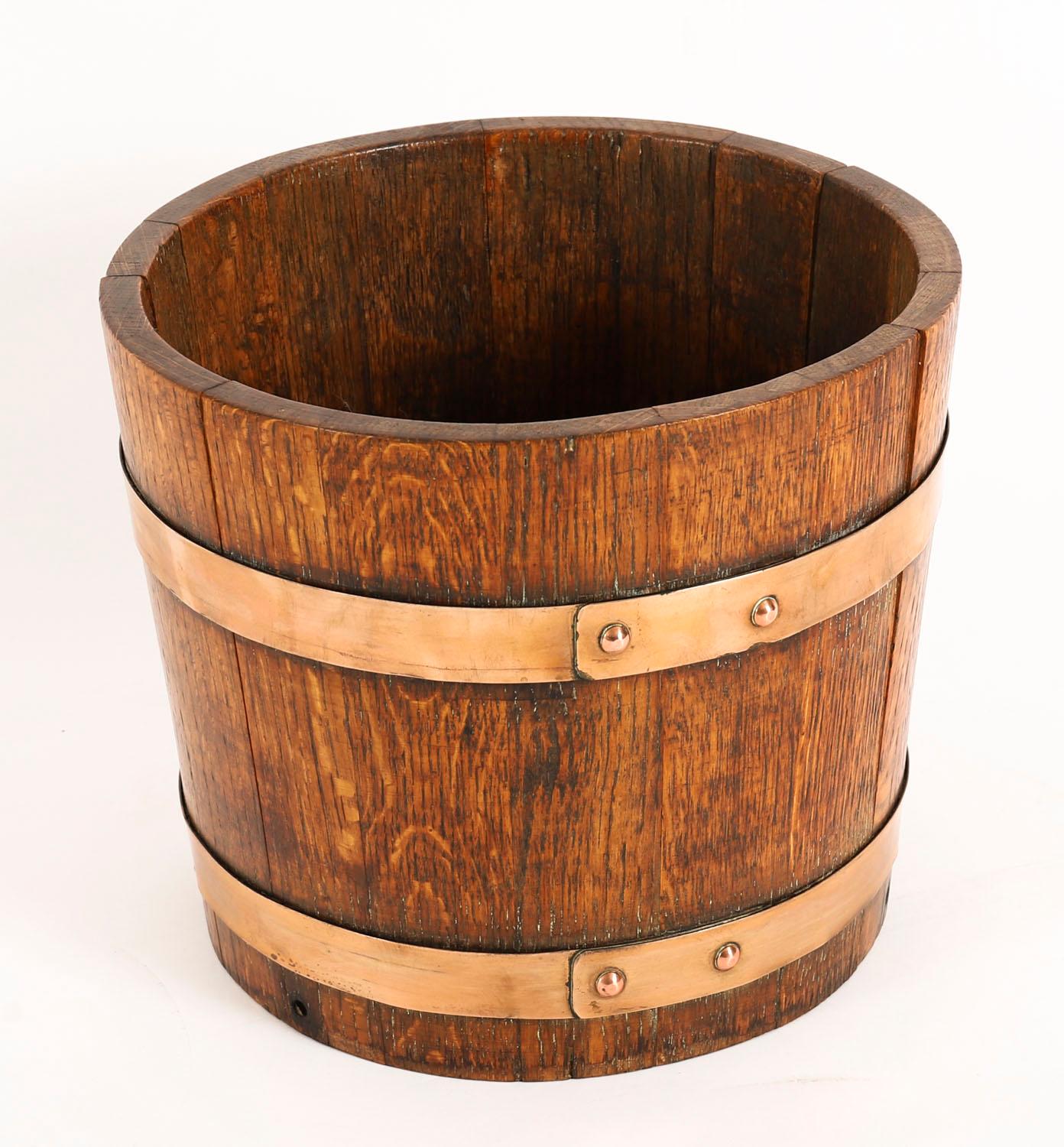 Si tratta di un elegante jardiniere in ottone di Lister of Dursley, risalente al 1840 circa. 

Il supporto in quercia è a forma di barile rotondo e presenta due fasce di ottone, con un'affascinante patina dovuta all'età.

Si tratta di un pezzo molto