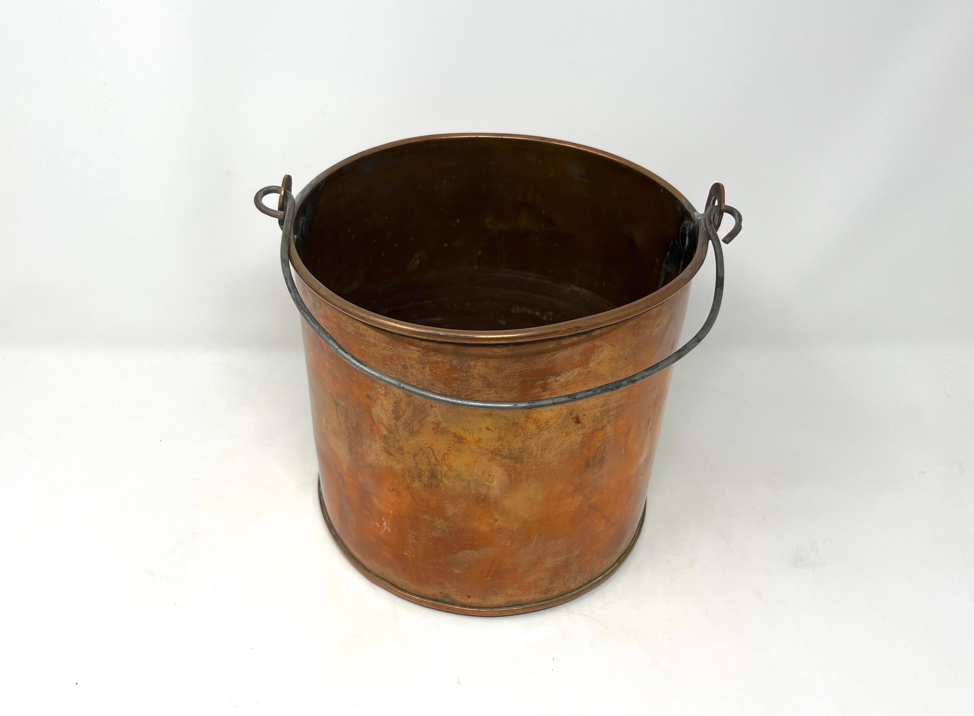 Late 19th century copper pot or bucket with rolled lip, iron handle, dovetailed seams at sides with brass solder and soldered hinges for handle. 

Great scale and ideal size to hold kindling or to use as a planter.

Measures 6-5/8
